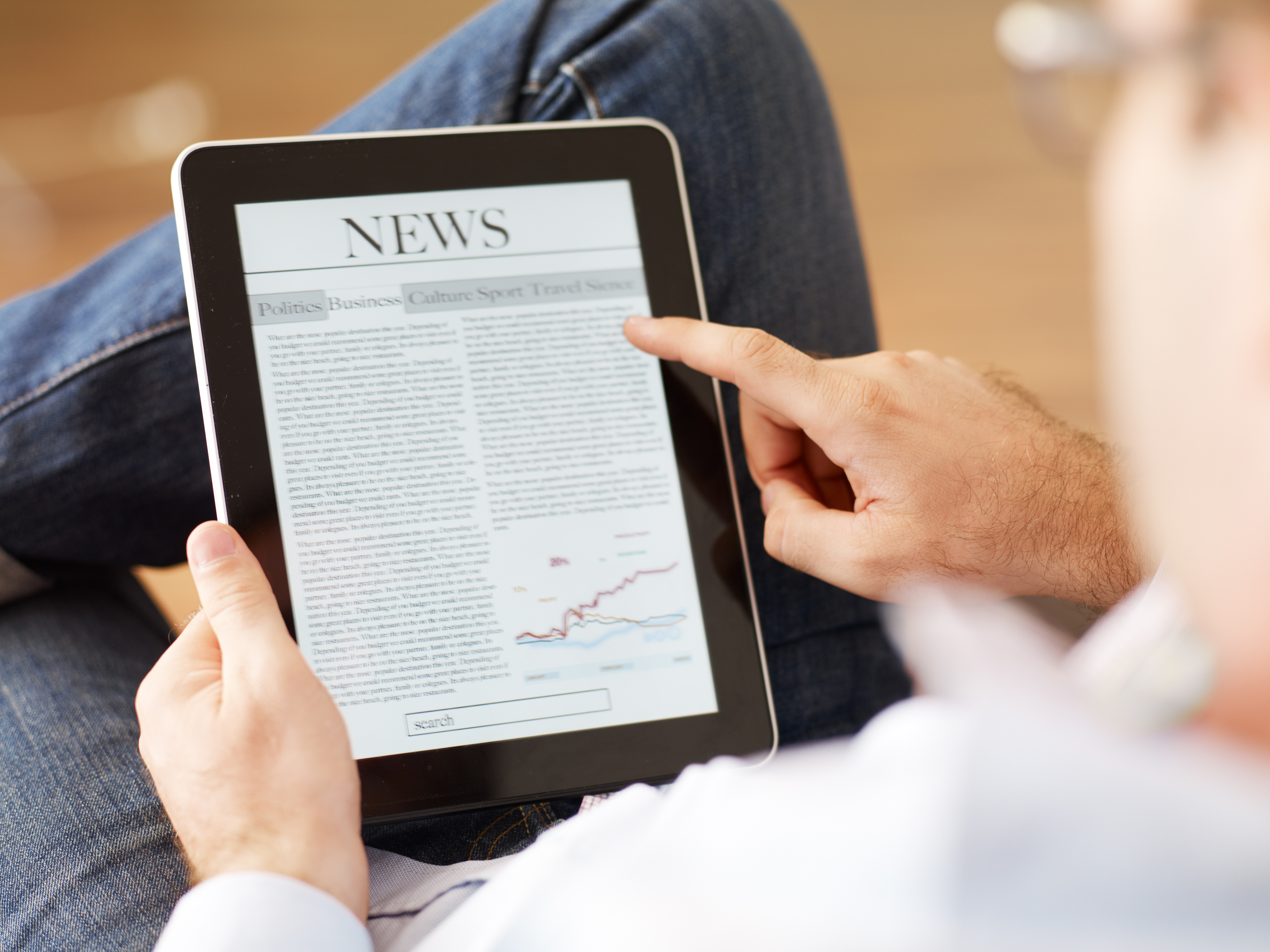 Man reading the newspaper on digital tablet