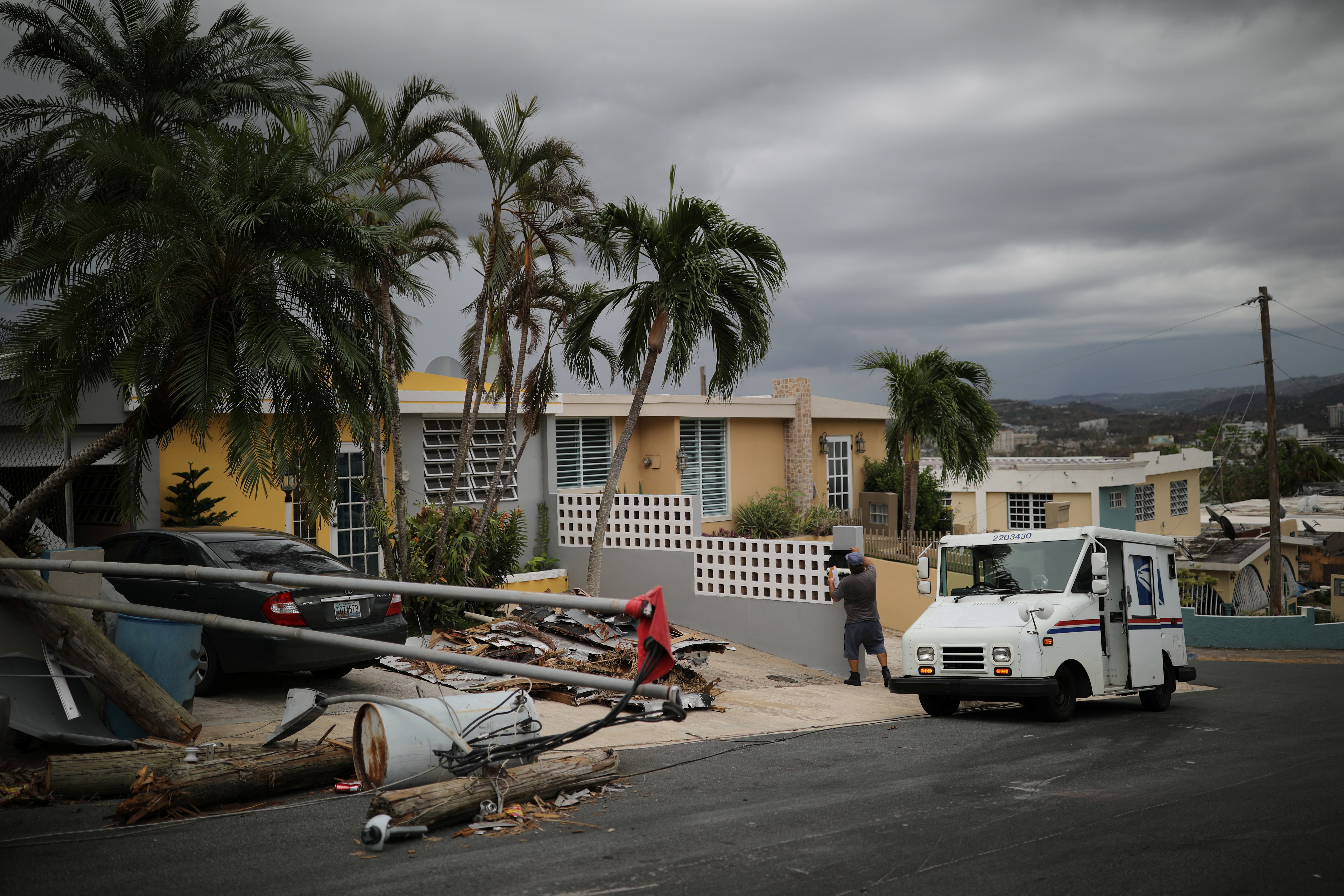Alfredo Martinez, a mail man for the U.S. Postal Service delivers the mail at an area damaged by Hurricane Maria in San Juan, Puerto Rico