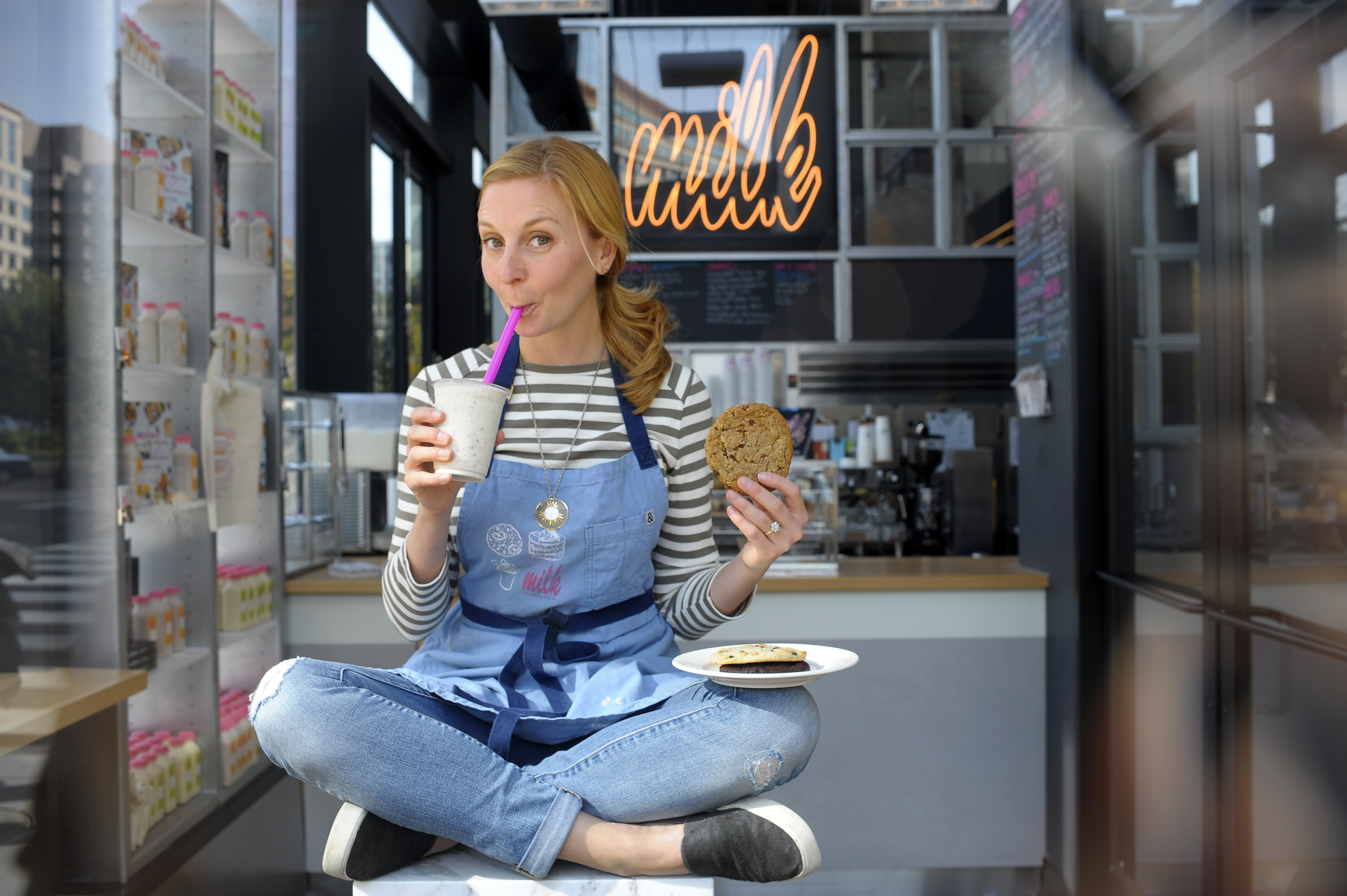 Milk Bar's Christina Tosi poses with milk and cookie in overalls