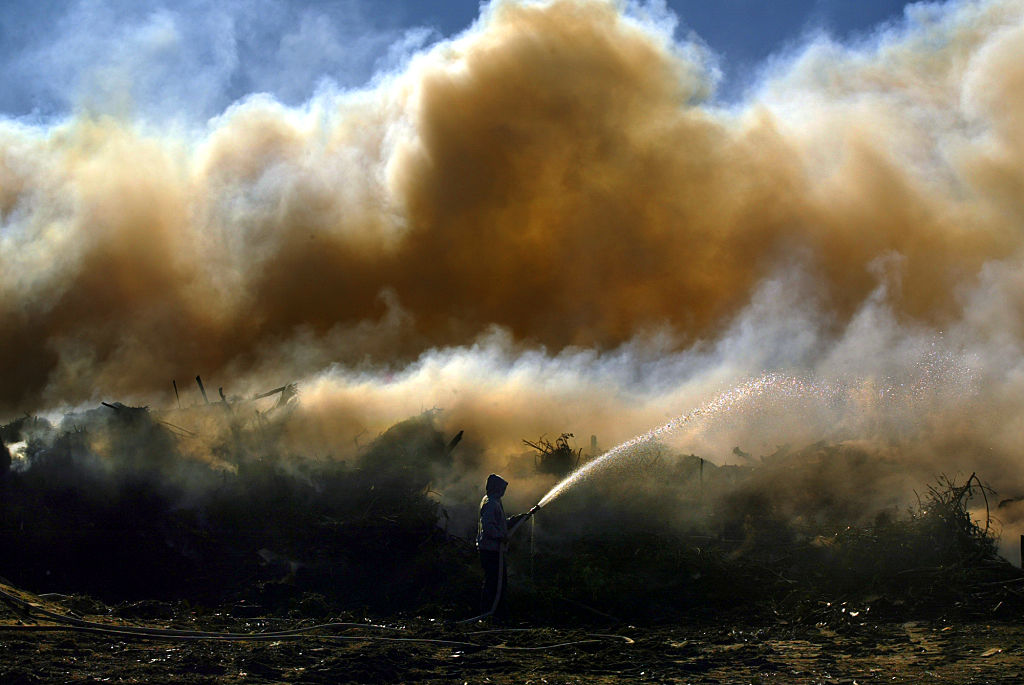 Chino. Nov. 29, 2004. Jose Ramirez (Cq) 28, douses smoldering green waste on Monday morning fir