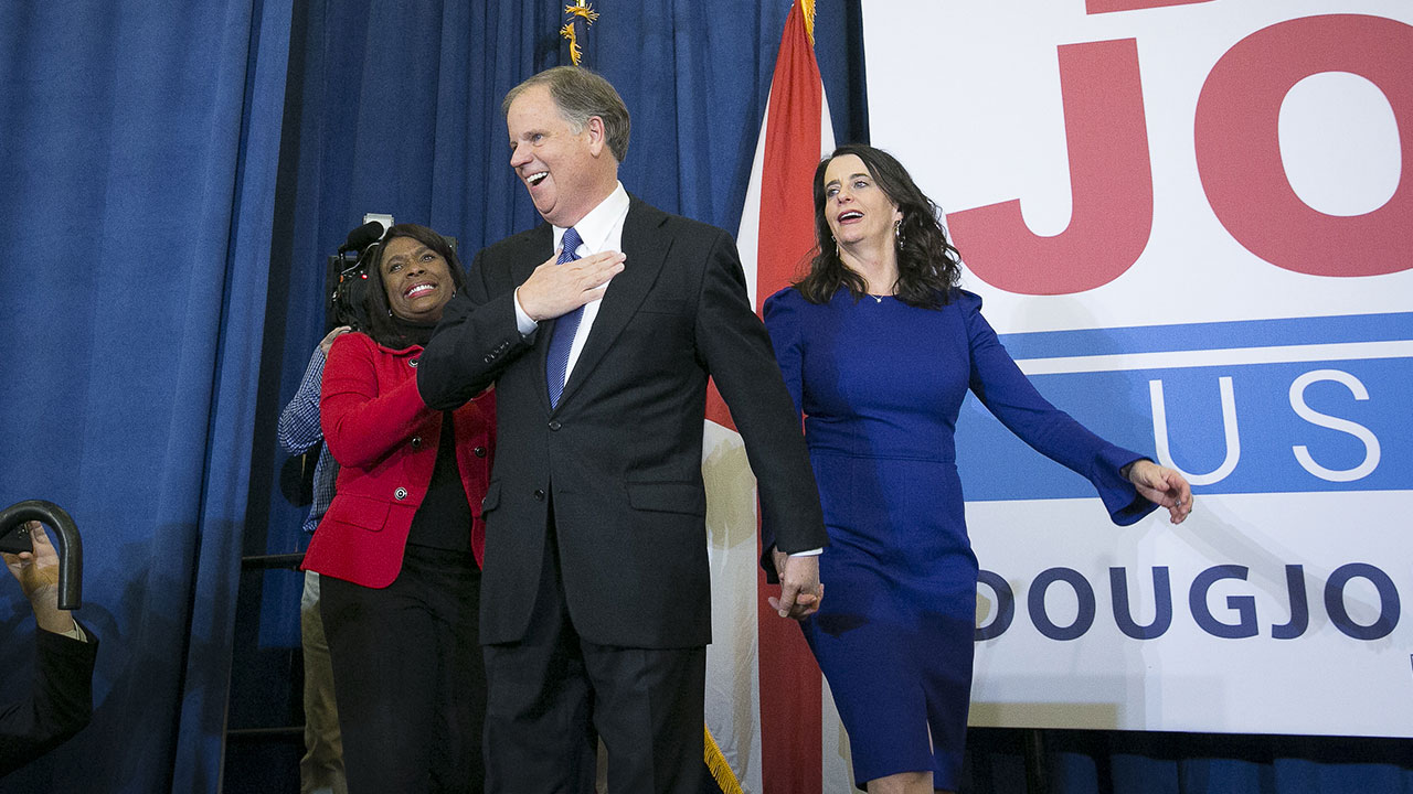 Senator-elect Doug Jones, a Democrat from Alabama, center, and wife Louise Jones, right, greet the audience at an election night party in Birmingham, Alabama, U.S., on Tuesday, Dec. 12, 2017. Jones delivered a stunning upset defeat to Republican Roy Moore in a U.S. Senate race in deep-red Alabama that had split the GOP even before its controversial nominee was accused of inappropriate conduct with teenage girls. Photographer: Nicole Craine/Bloomberg via Getty Images