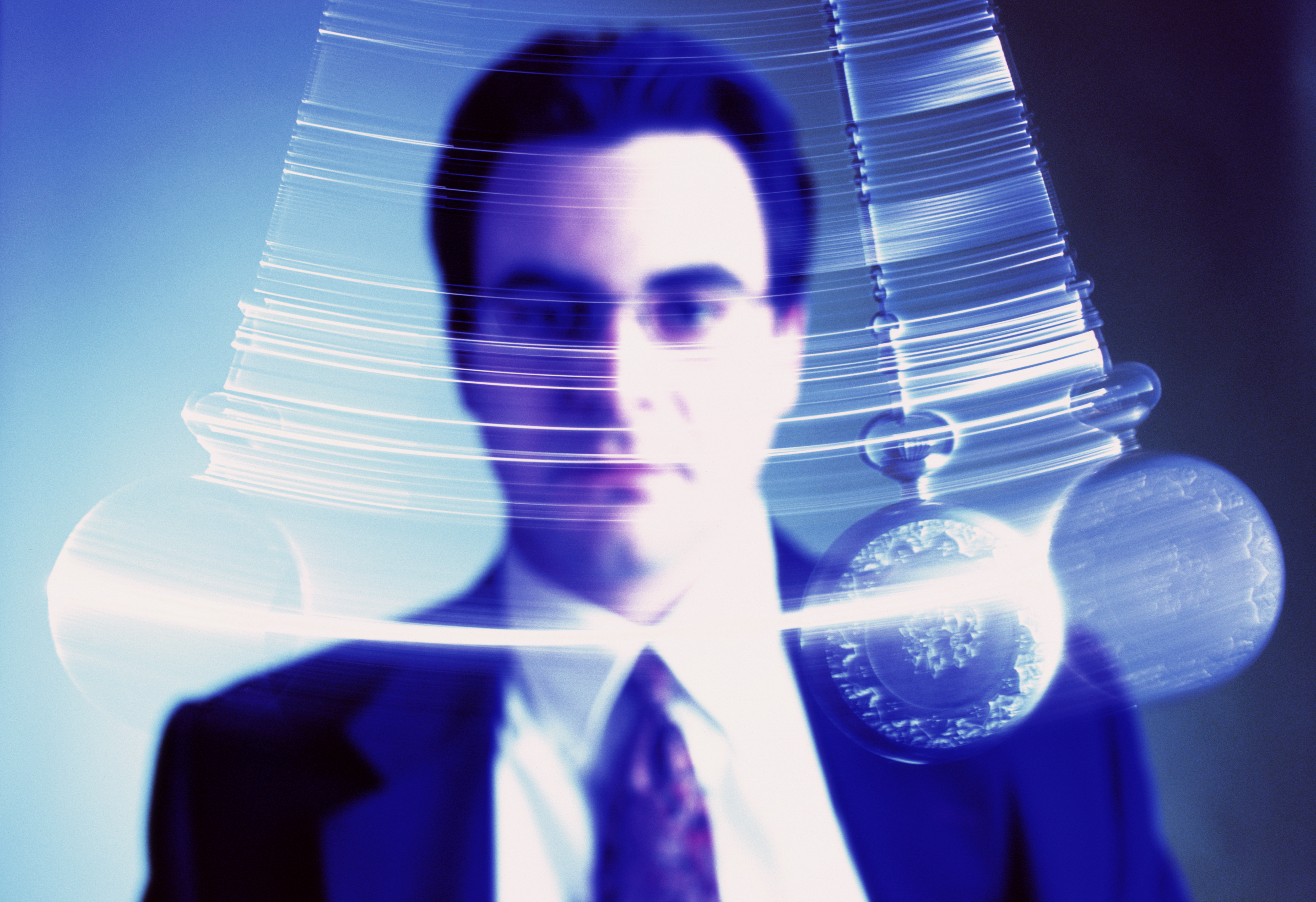 Businessman watching swinging pendulum (Digital Enhancement)