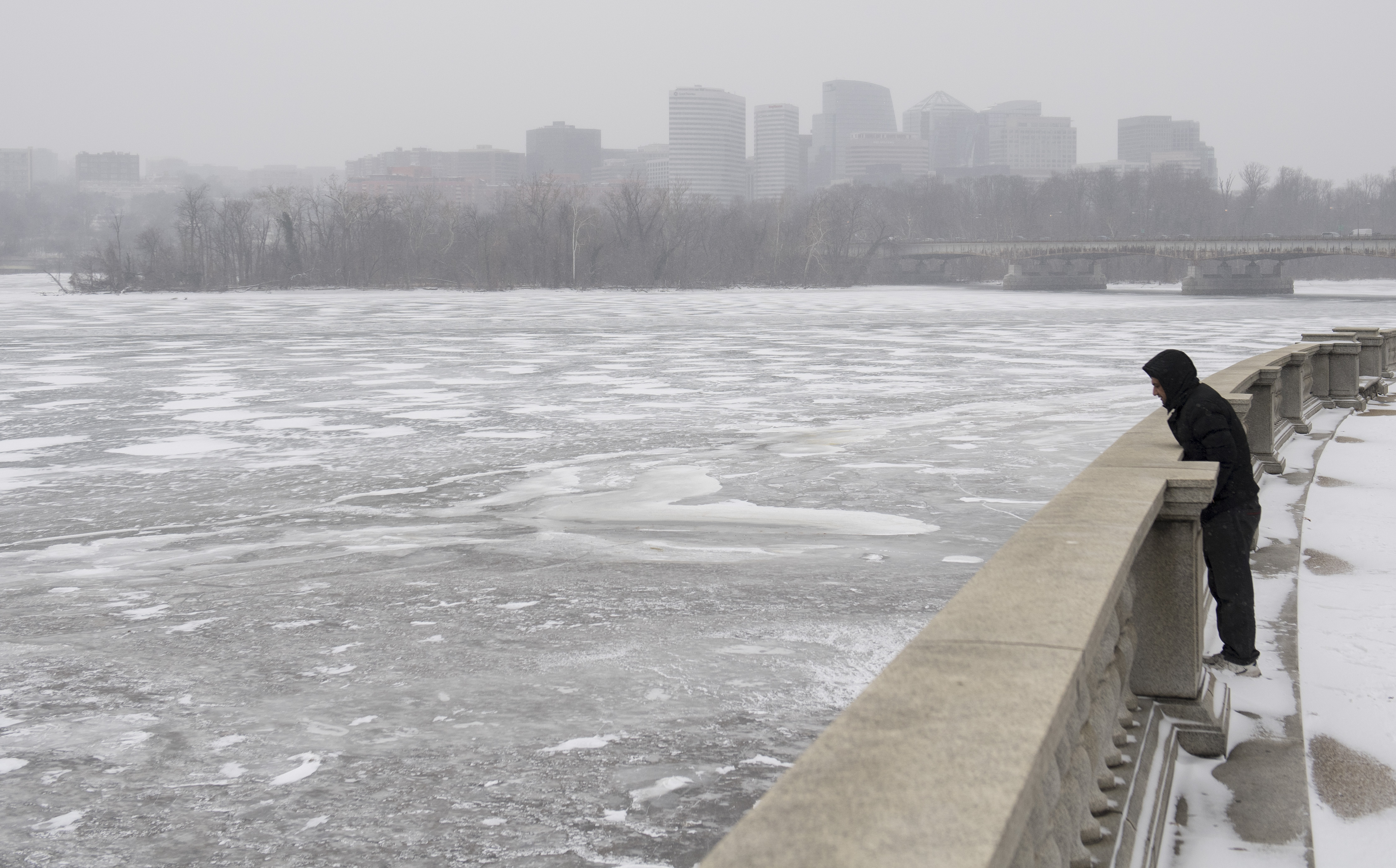 A man looks out over a frozen Potomac River during a snow storm in Washington, DC, January 4, 2018.