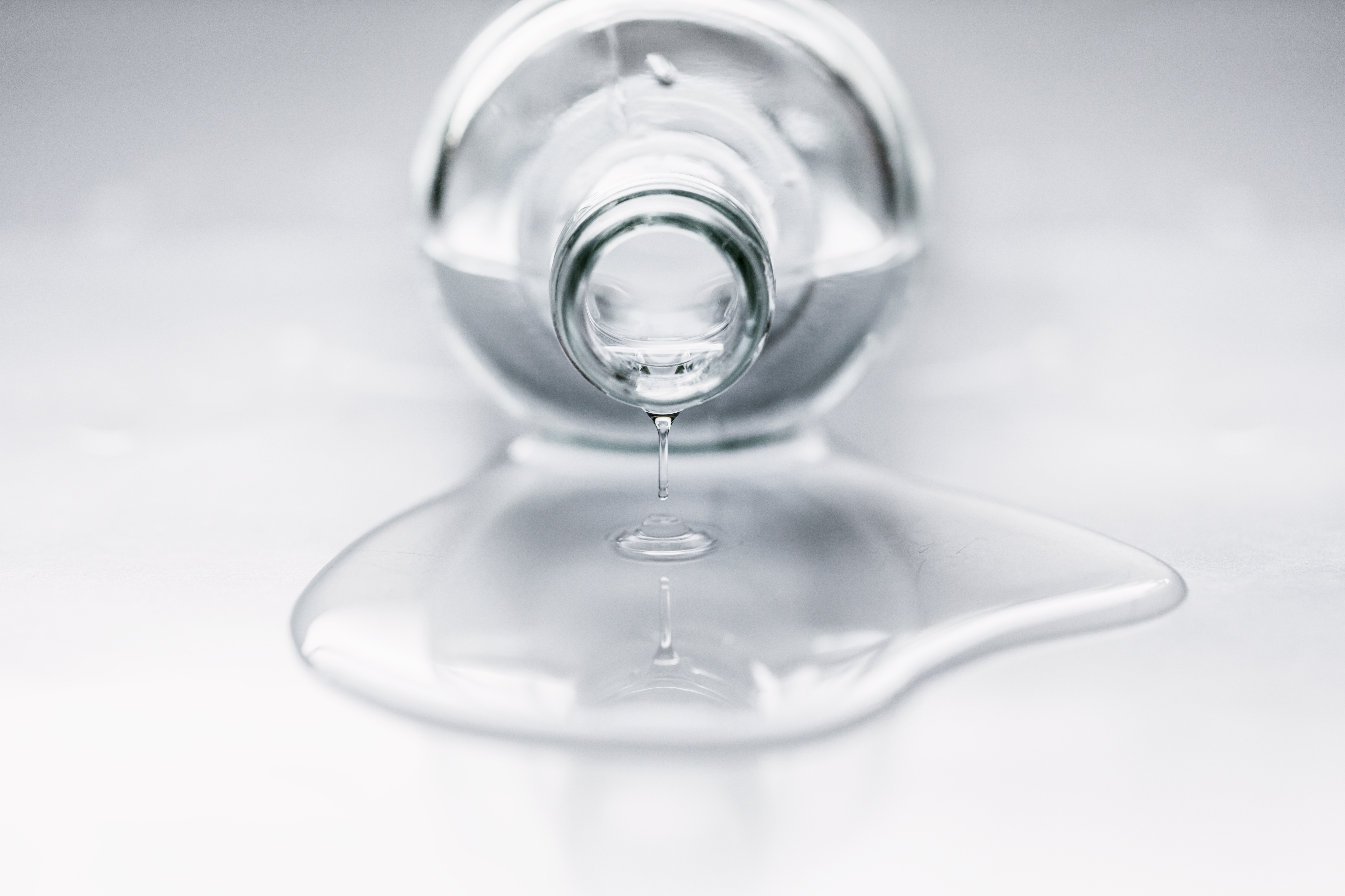 Bottle lying on table with water coming out