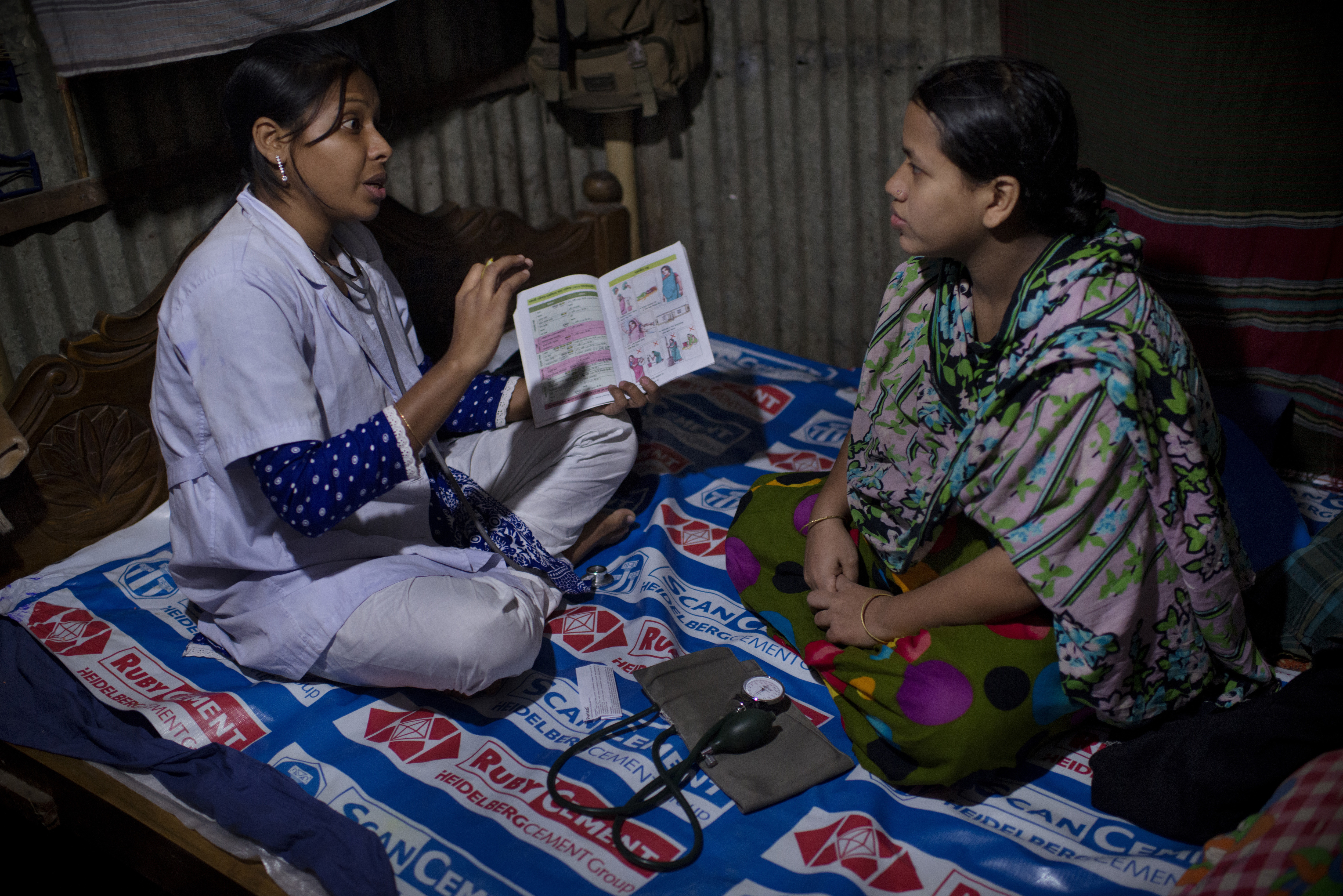 A doctor performs a checkup on a pregnant woman living in a slum of Dhaka.