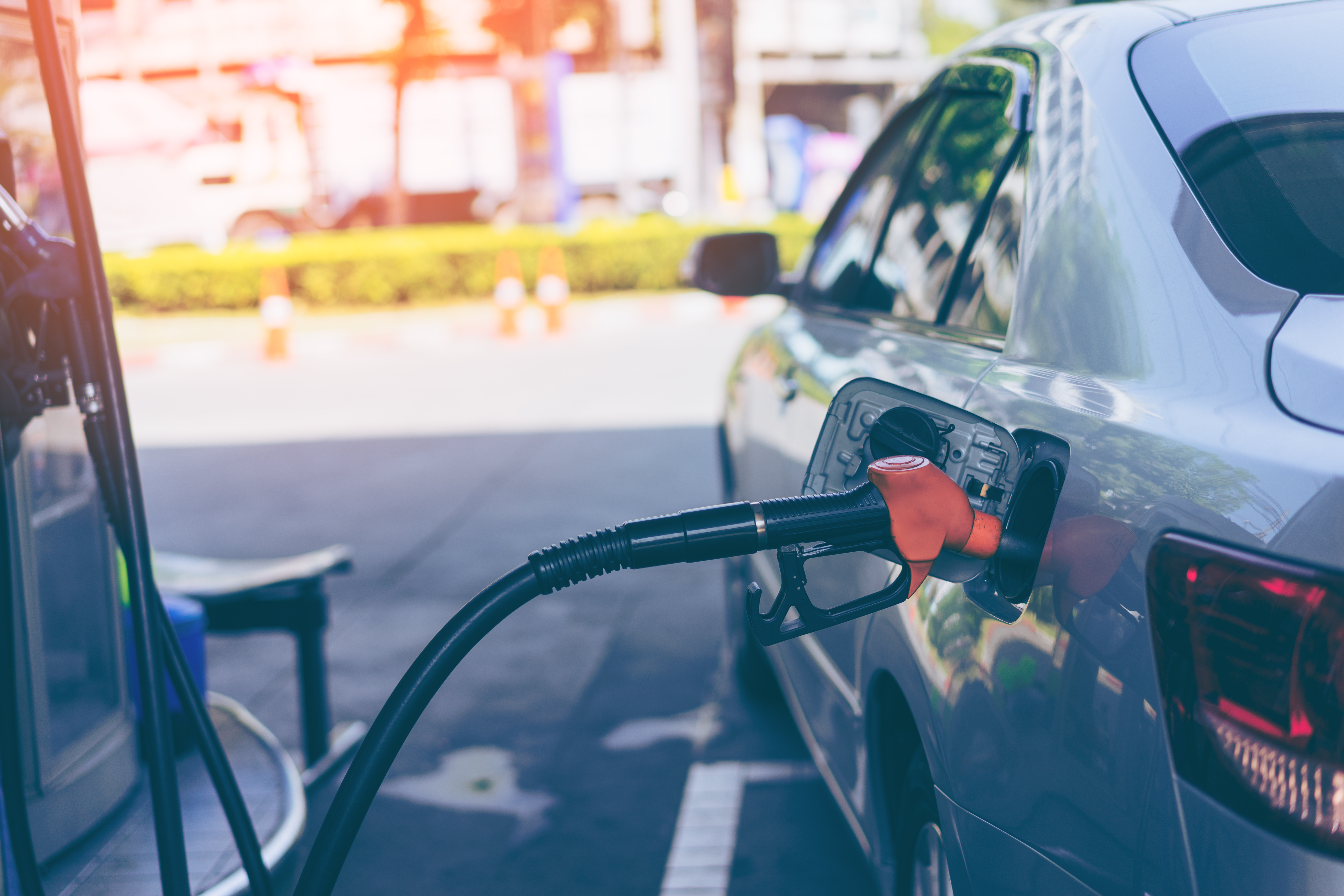 Pumping gasoline fuel in car at gas station.