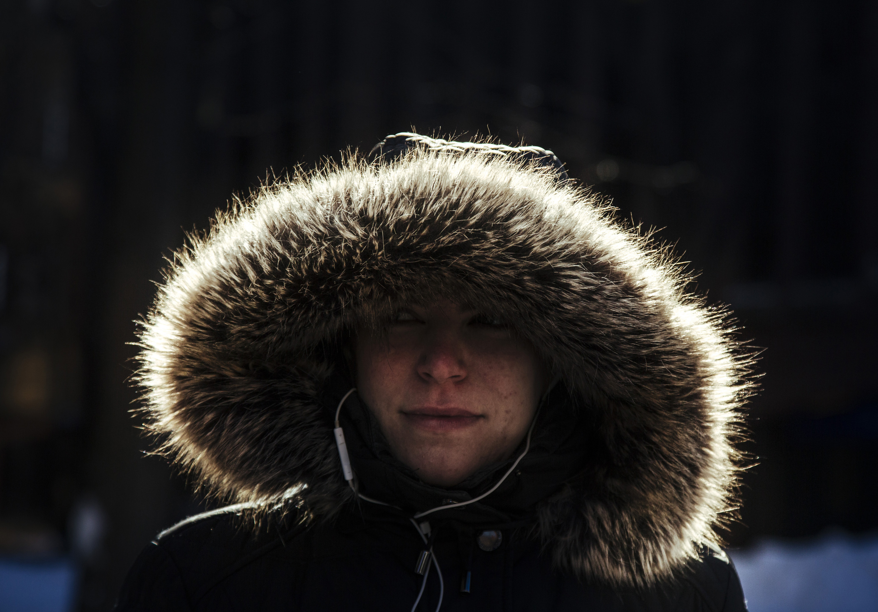 Woman wears hooded coat with fur trim in cold weather