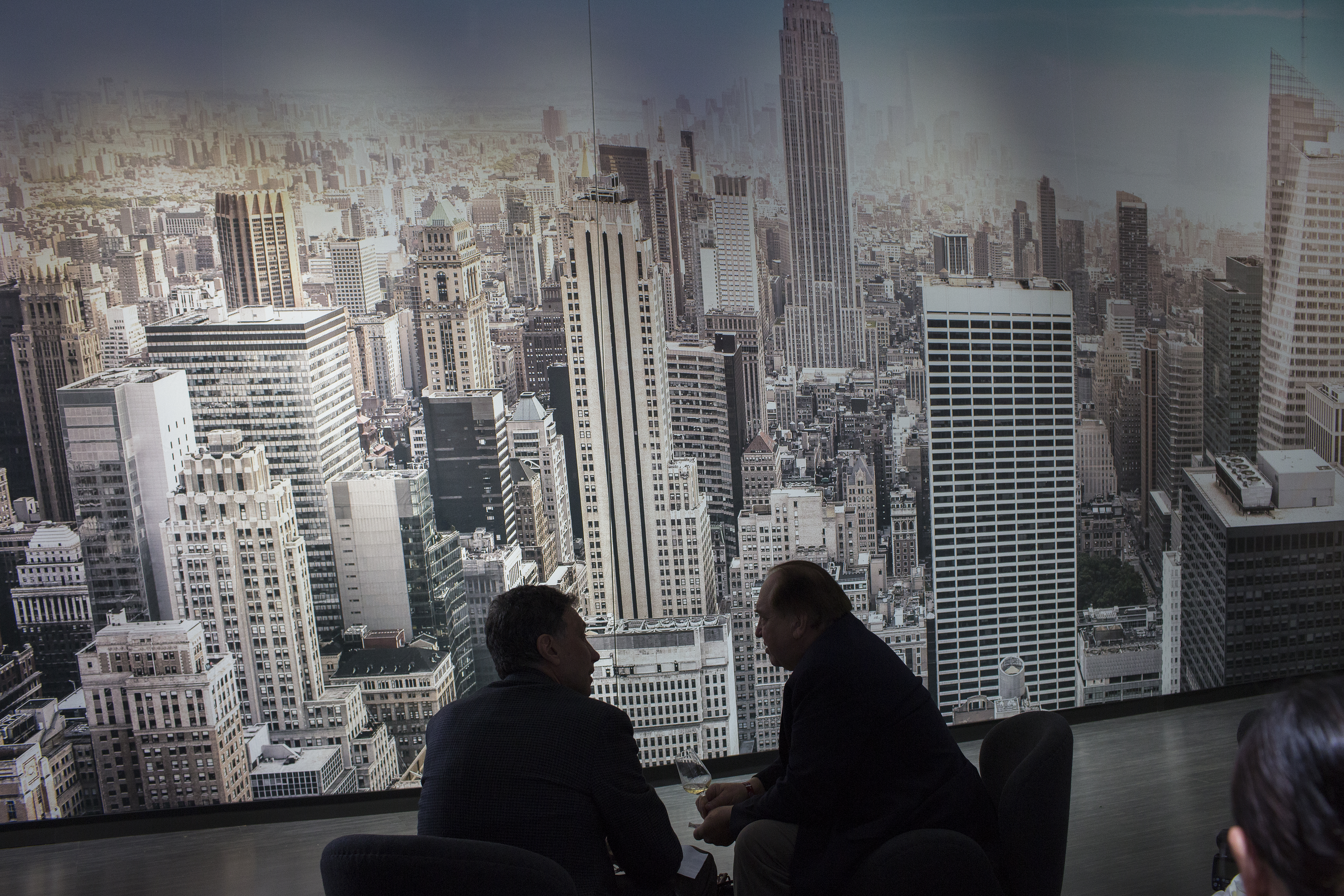 Two men silhouetted against New York City skyline.