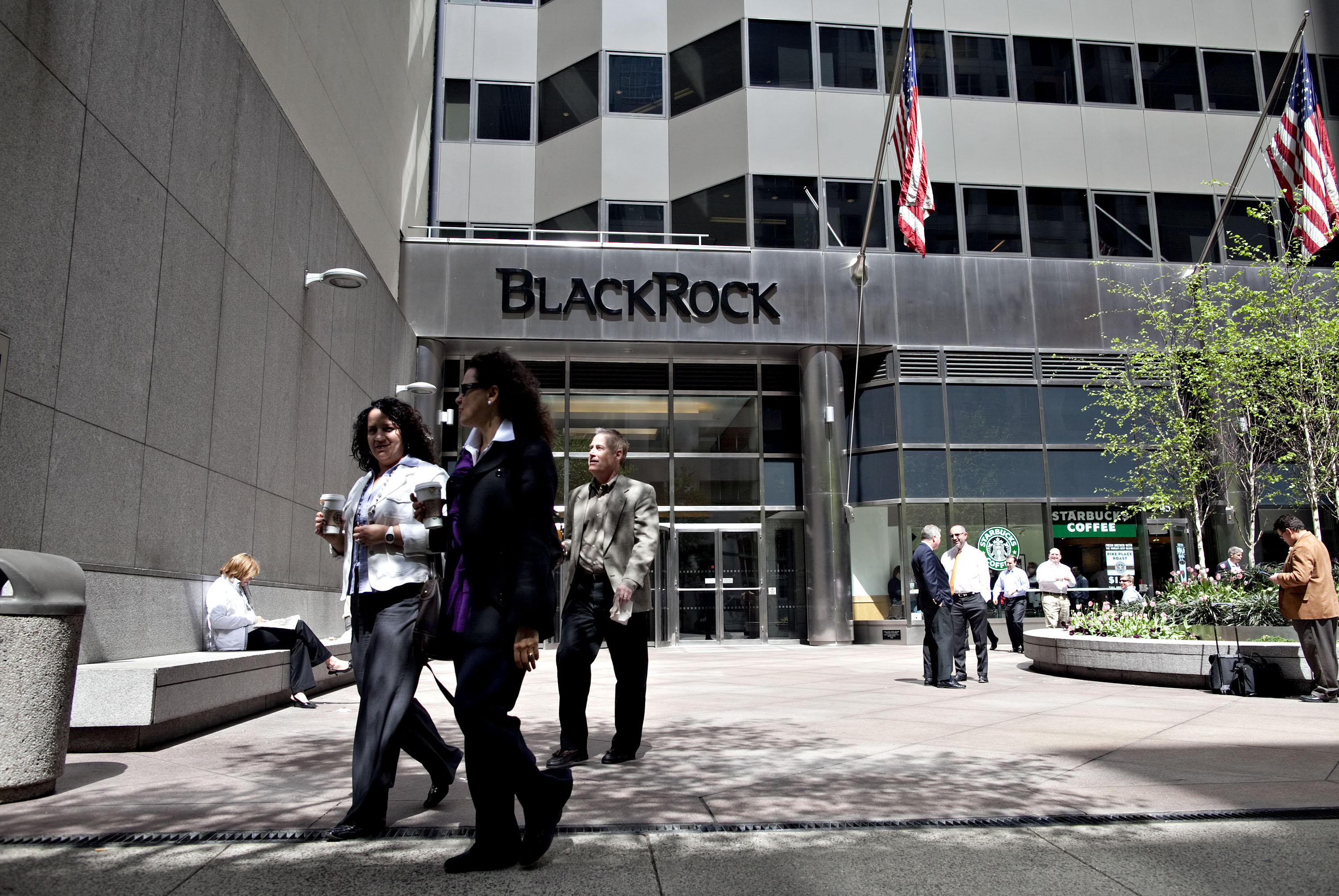 Pedestrians walk outside the headquarters of BlackRock Inc.