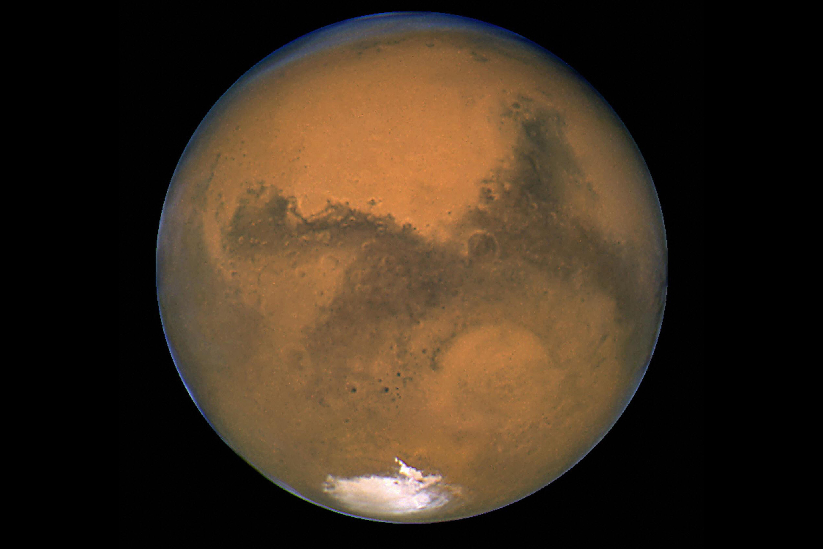 IN SPACE - AUGUST 26: This image released August 27, 2003 captured by NASA's Hubble Space Telescope shows a close-up of the red planet Mars when it was just 34,648,840 miles (55,760,220 km) away. This color image was assembled from a series of exposures taken between 6:20 p.m. and 7:12 p.m. EDT August 26, 2003 with Hubble's Wide Field and Planetary Camera 2. The picture was taken just 11 hours before the planet made its closest approach to Earth in 60,000 years. Many small, dark, circular impact craters can be seen, attesting to the Hubble telescope's ability to reveal fine detail on the planet's surface. (Photo by NASA/Getty Images)
