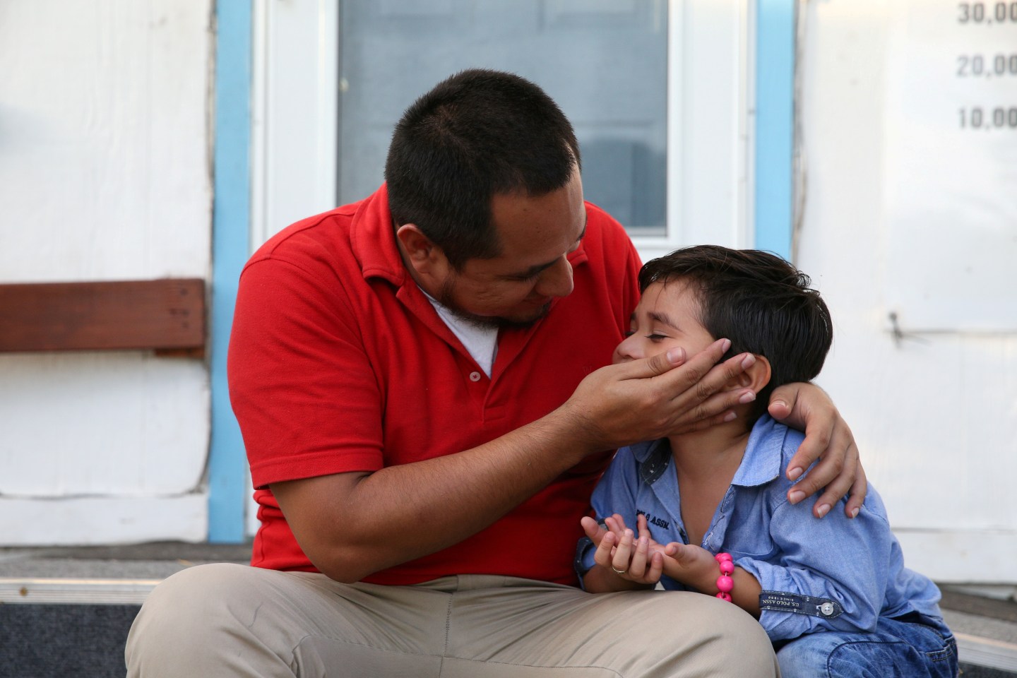 An asylum seeker from El Salvador and his young son arrive at a shelter in San Benito after he said they were reunited following separation since late May while in detention