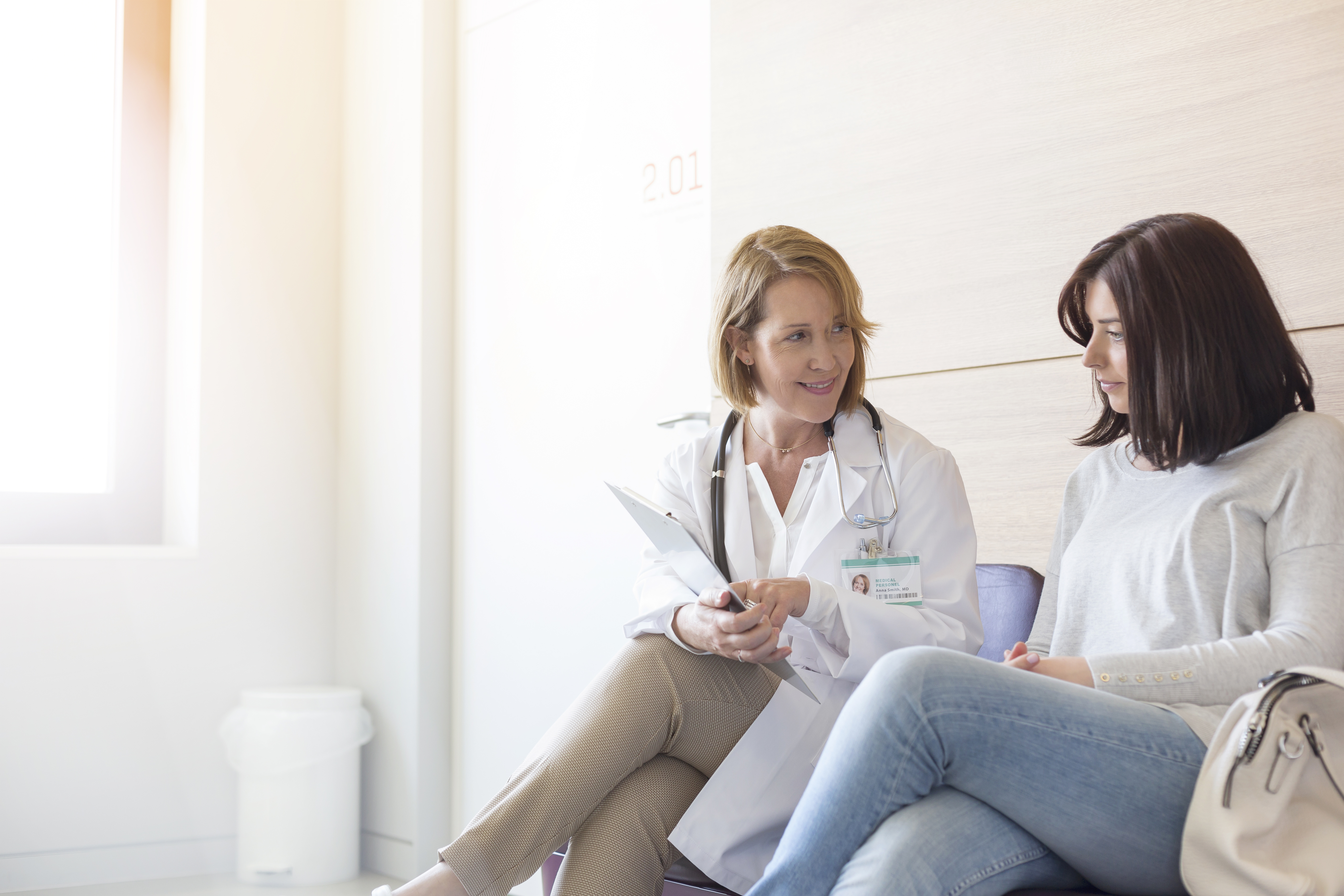 Doctor and patient reviewing medical record in clinic lobby
