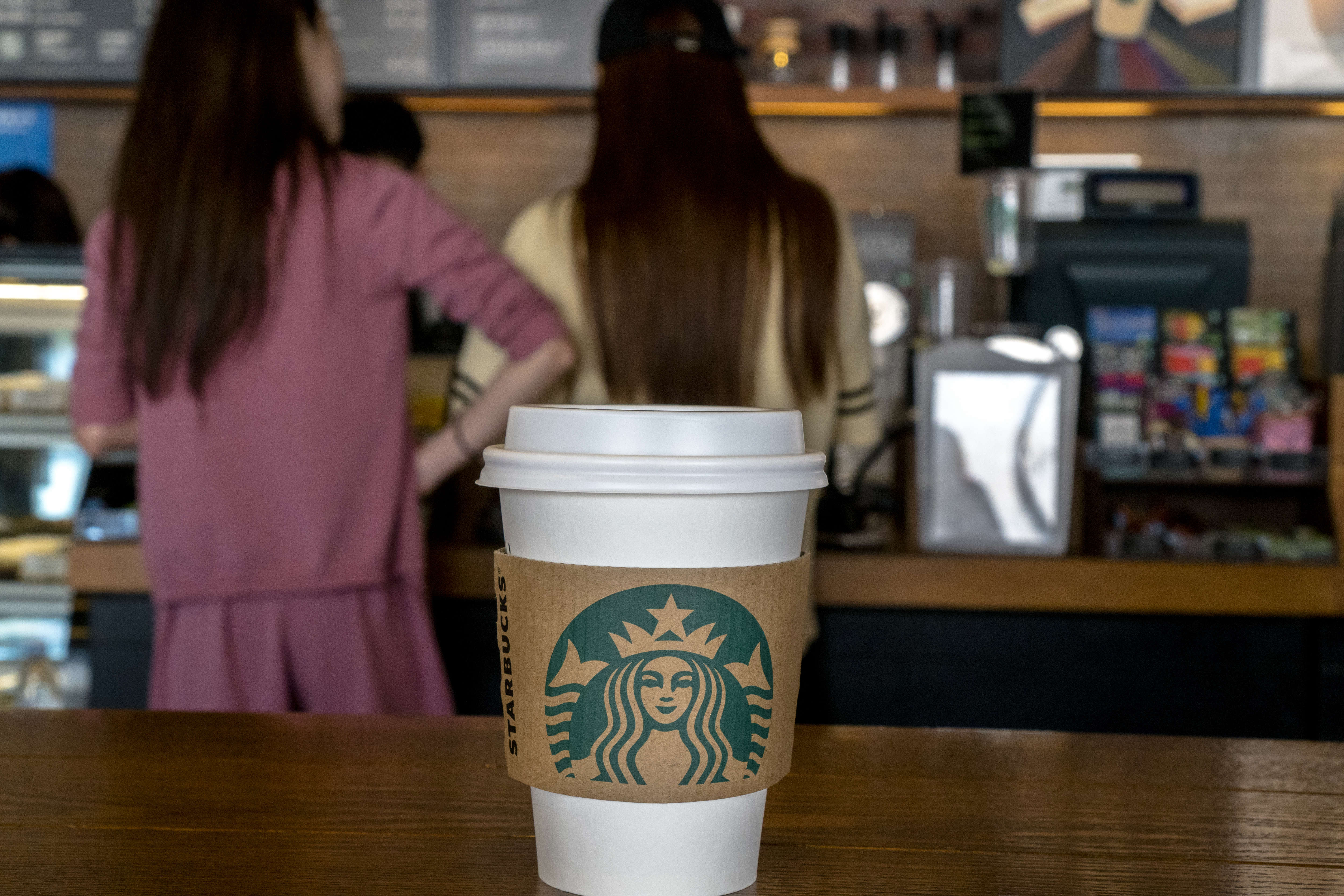 Young girls buy coffee in a Starbucks shop. During the