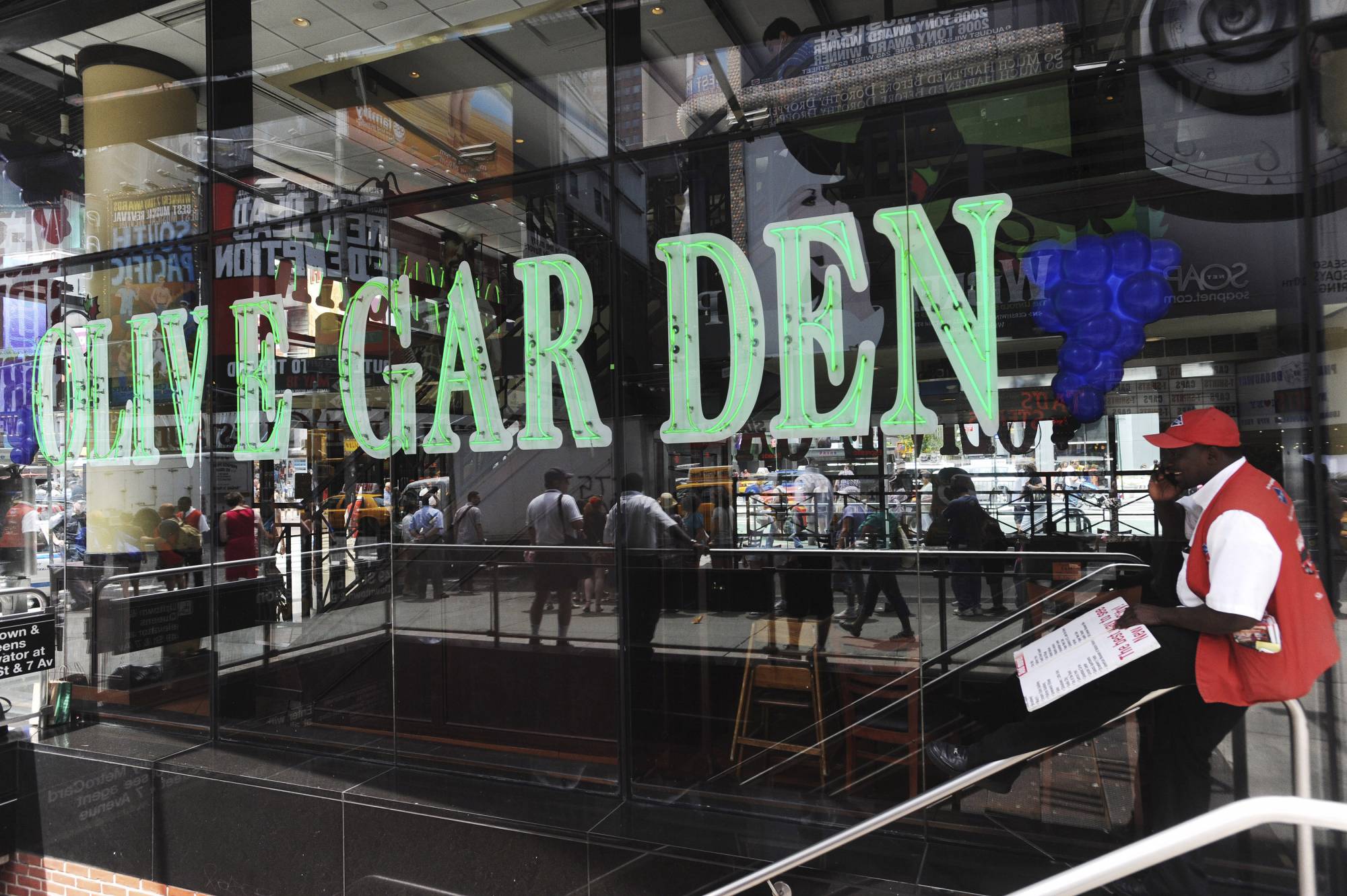 A man talks on his mobile phone in front of the Times Square Olive Garden in New York