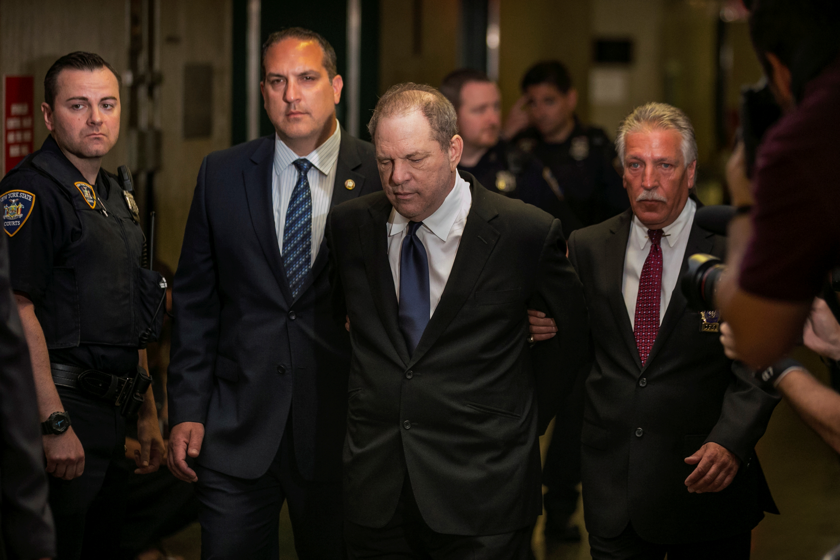 Film producer Harvey Weinstein is led handcuffed by police into his hearing at Manhattan Criminal Court in New York