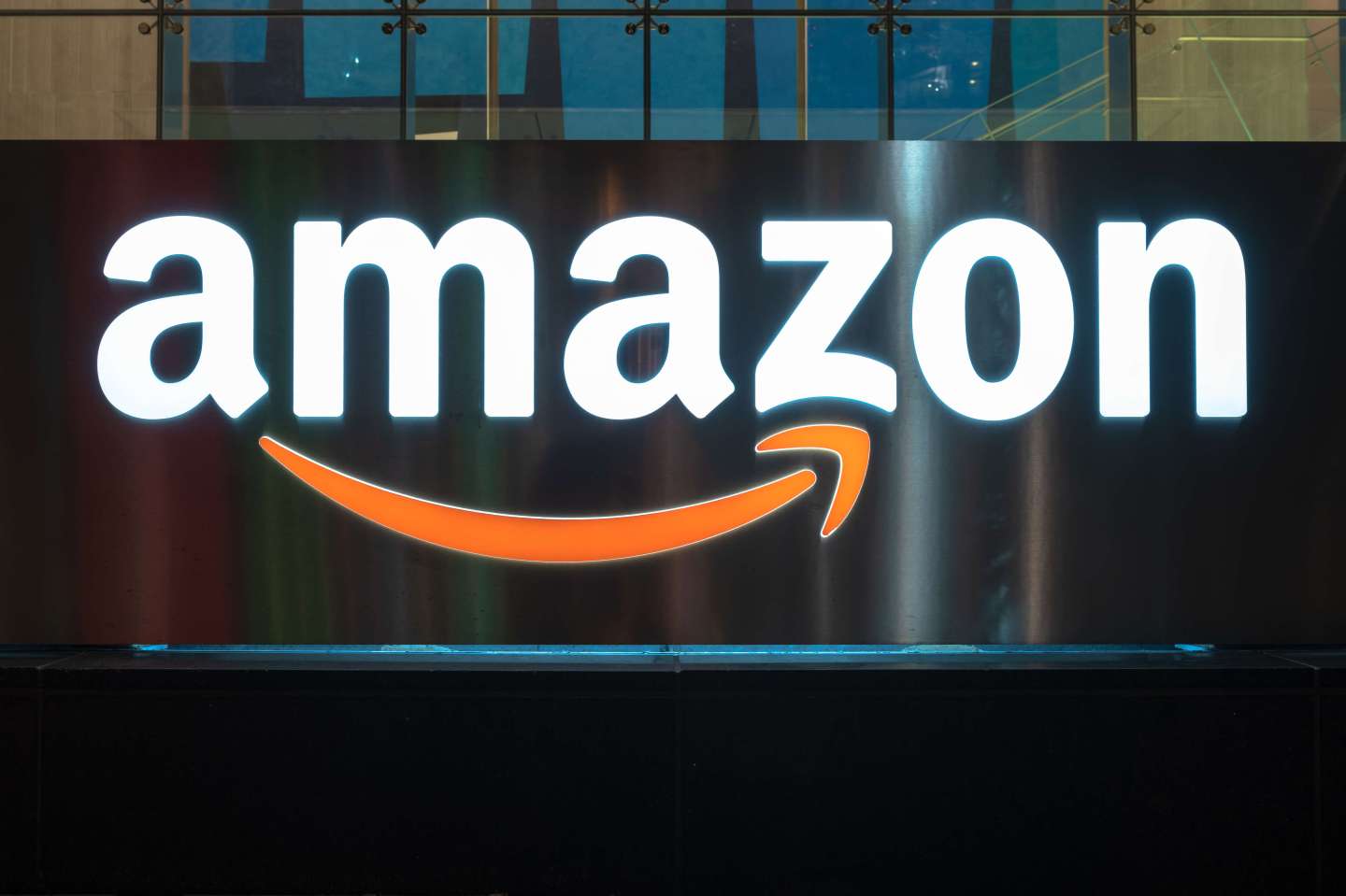 The Amazon logo illuminated at night. The sign can be seen