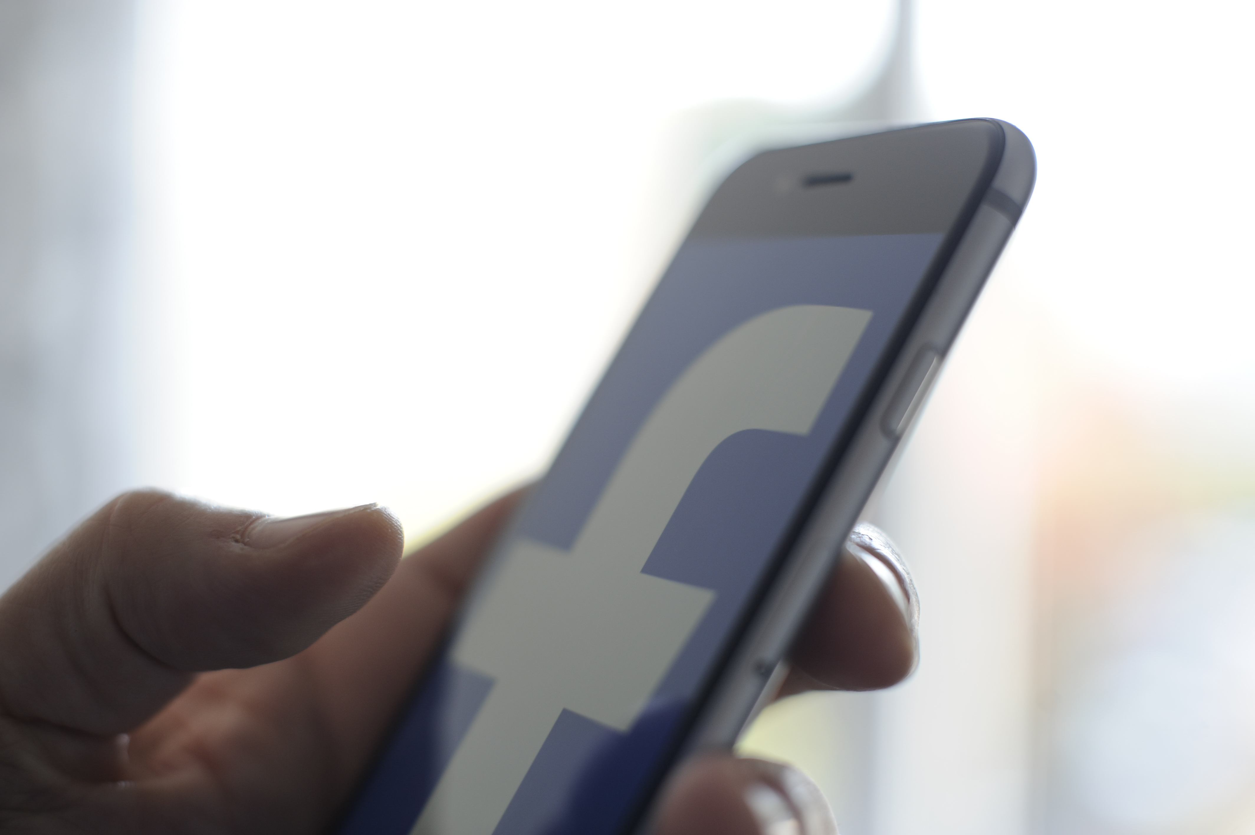 The Facebook logo is seen on an Apple iPhone.