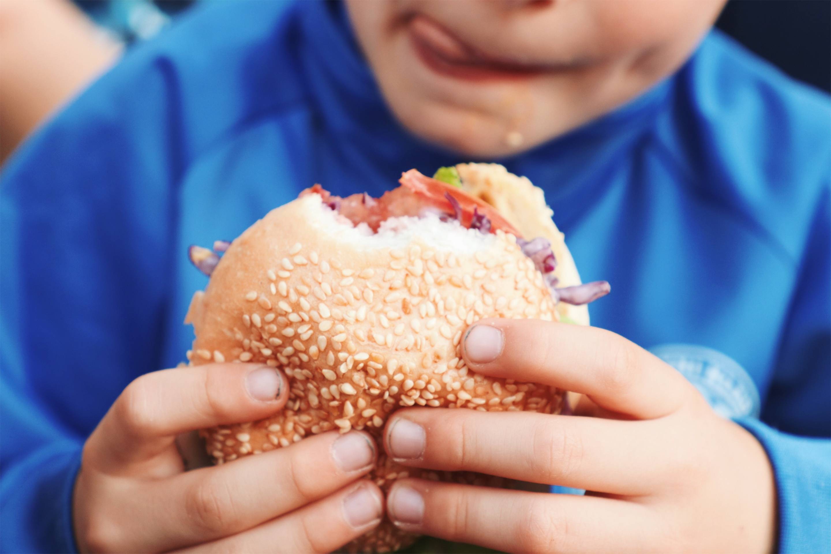 Midsection Of Boy Holding Burger