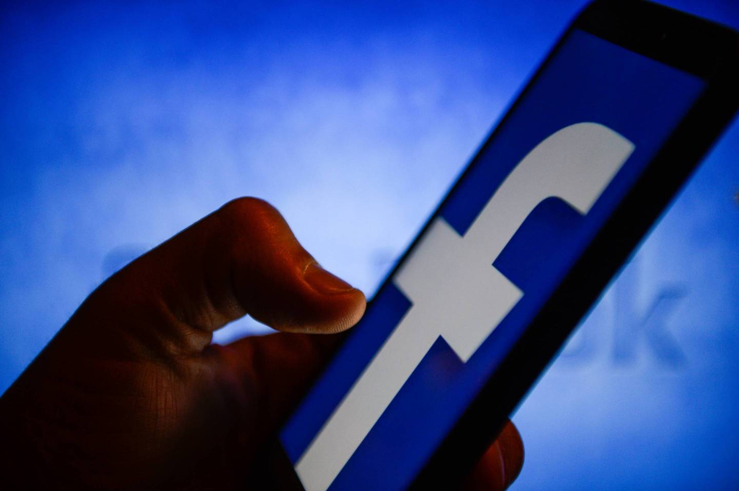 A Facebook logo is seen on a mobile phone.