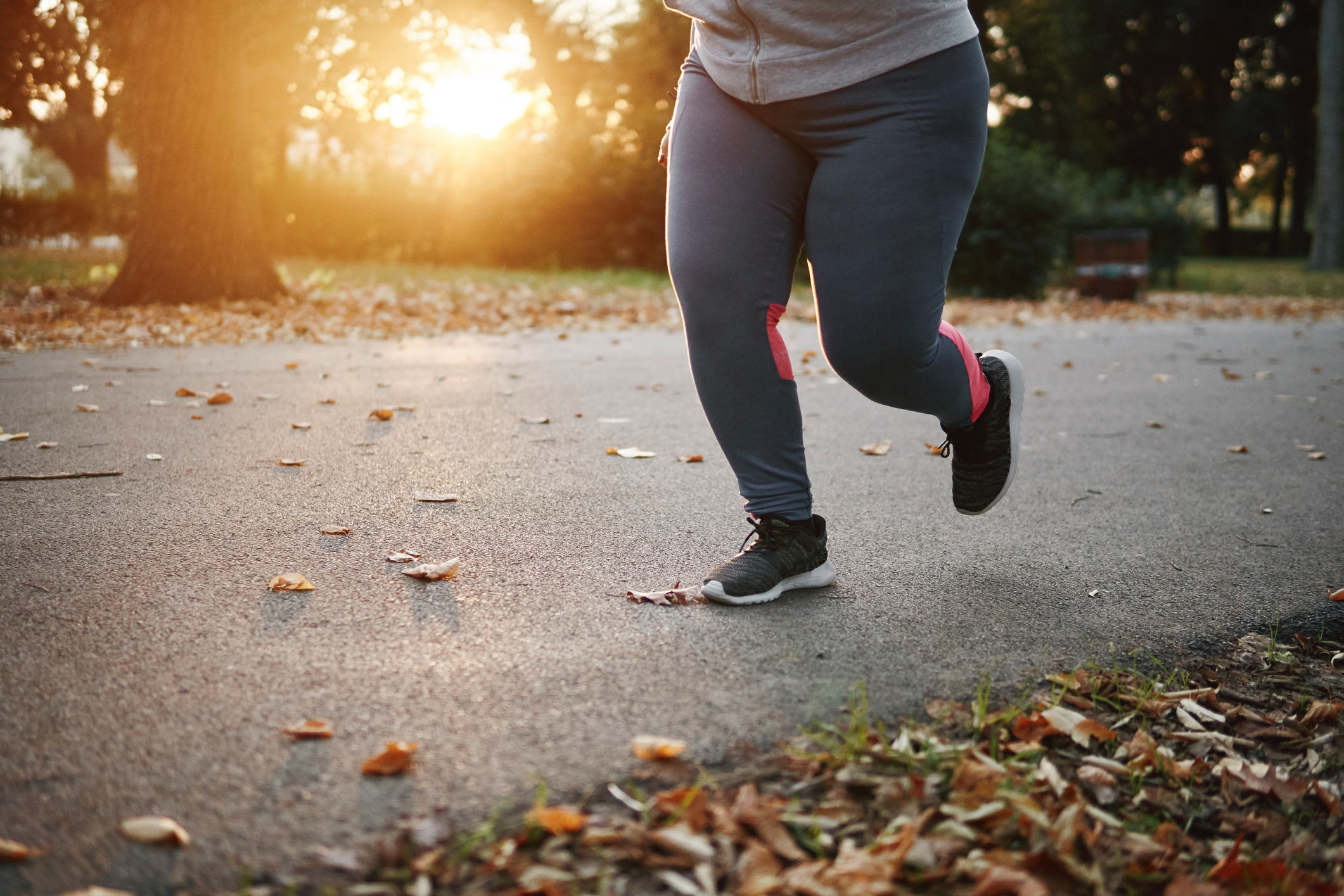young female runner running in park, waist down