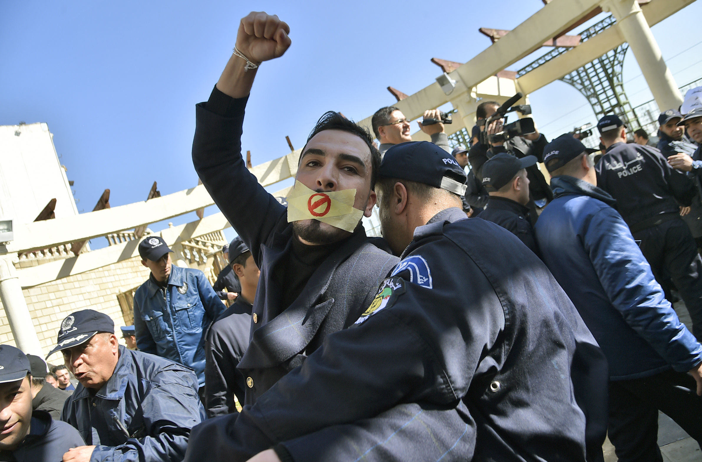 An Algerian policeman restrains a protester participating in a rally organized by journalists against alleged censorship of coverage of protests against a fifth term for veteran President Abdelaziz Bouteflika in Algiers on February 28, 2019.