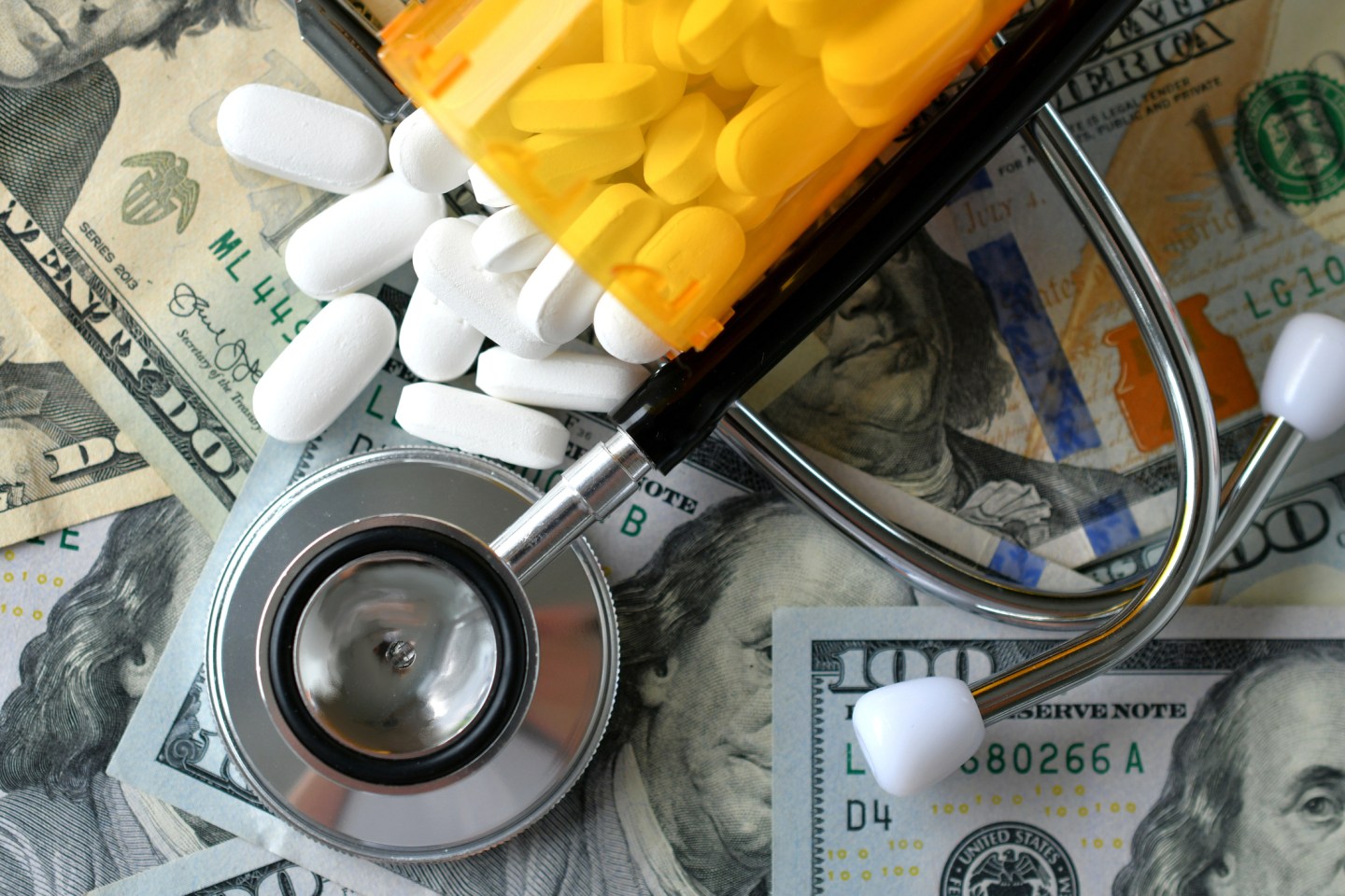High Angle View Of Pills Spilling On Paper Currency