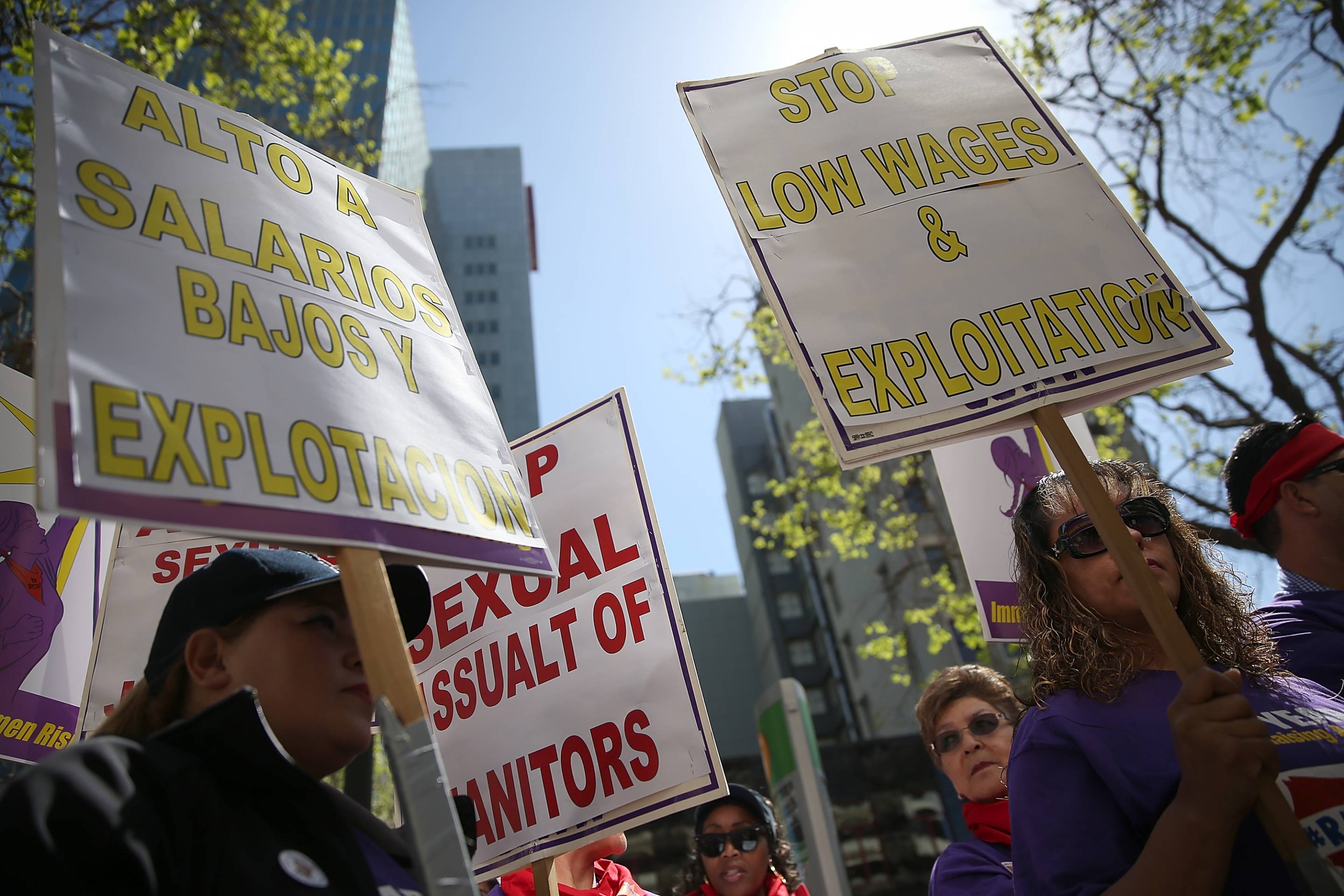 Union workers hold signs during a demonstration in support of a proposal to raise the California minimum wage to $15 by 2022 on March 31, 2016, in Oakland, Calif.
