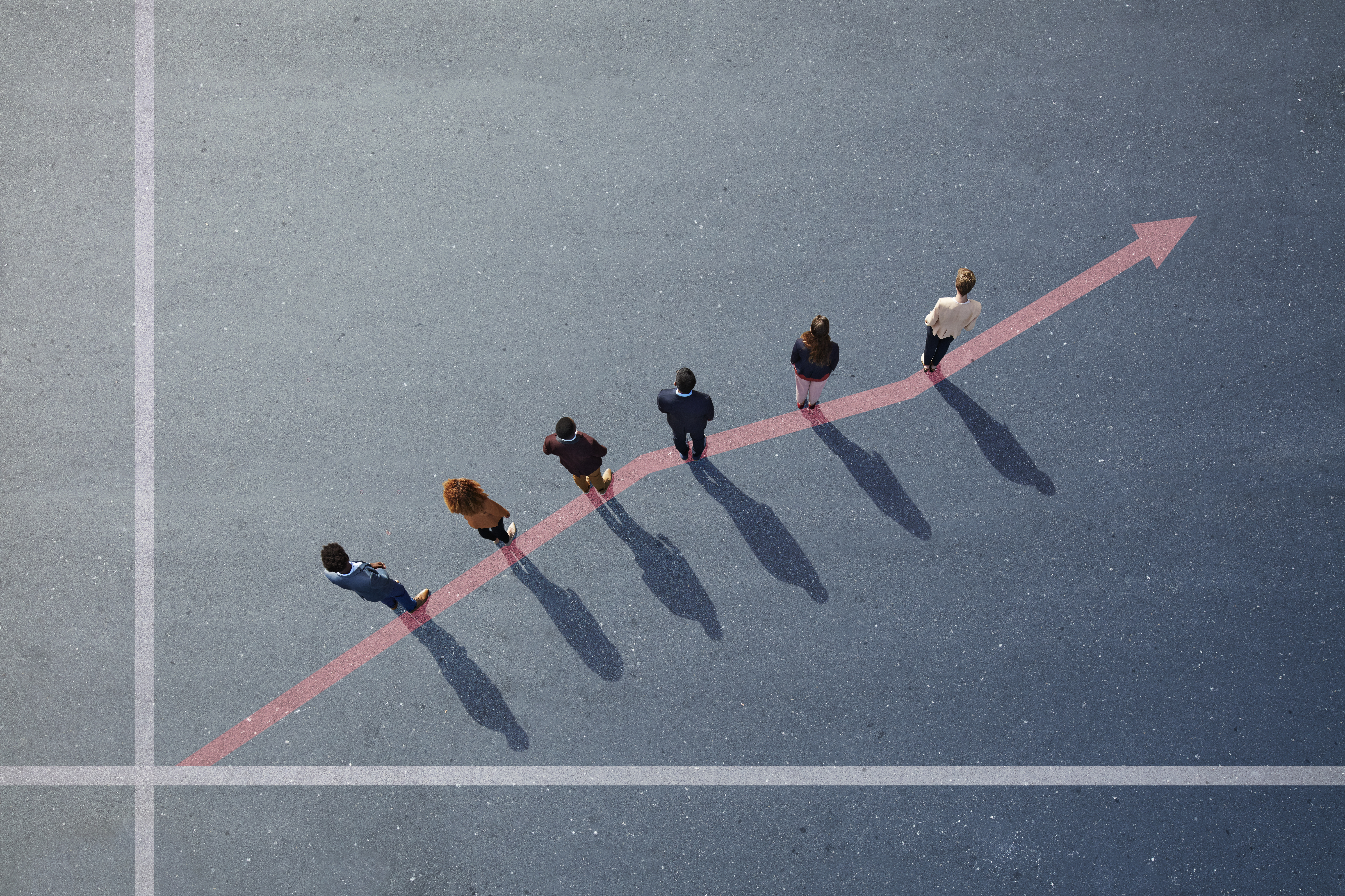 Businesspeople standing on painted up going graph on asphalt