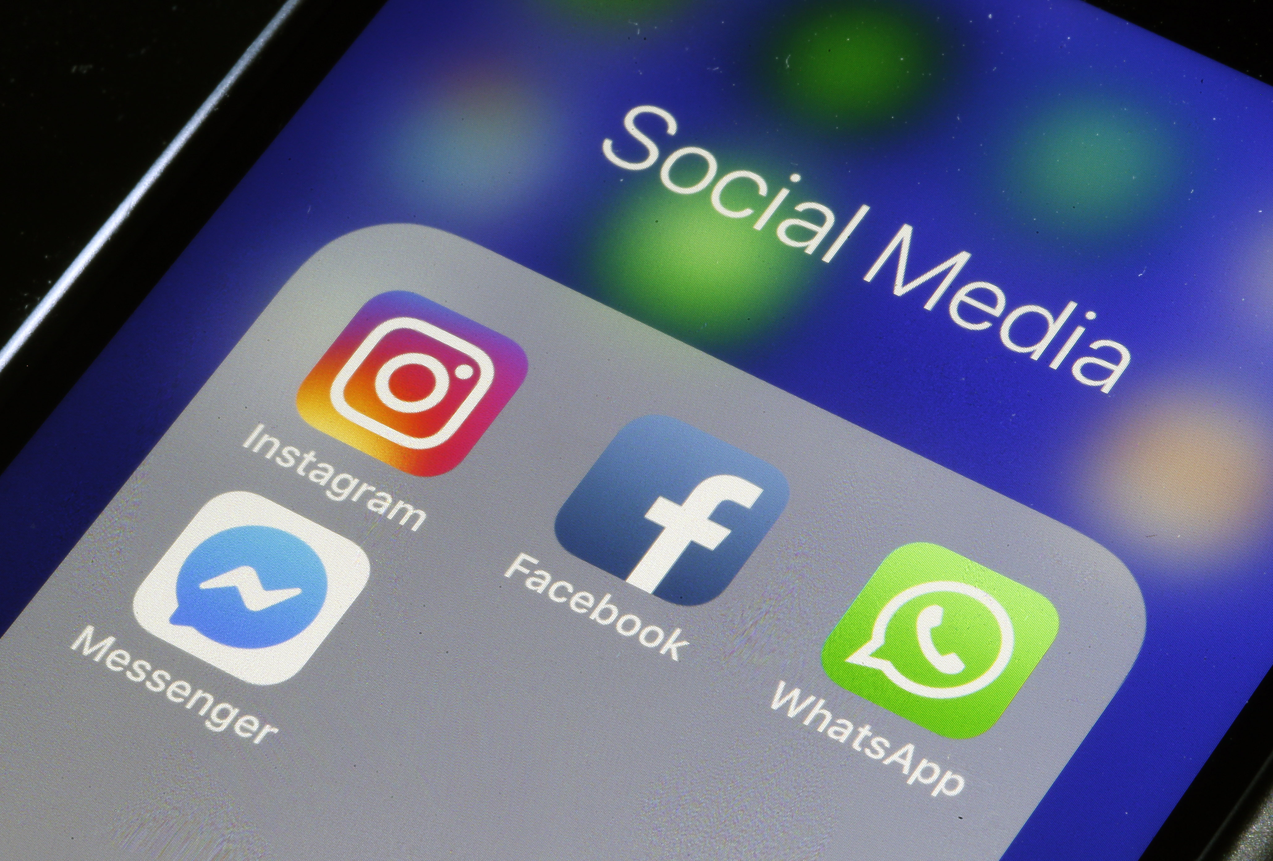 In this photo illustration, the logos of the messaging applications, WhatsApp, Instagram, Messenger and Facebook are displayed on the screen of an Apple iPhone. (Photo by Chesnot/Getty Images)
