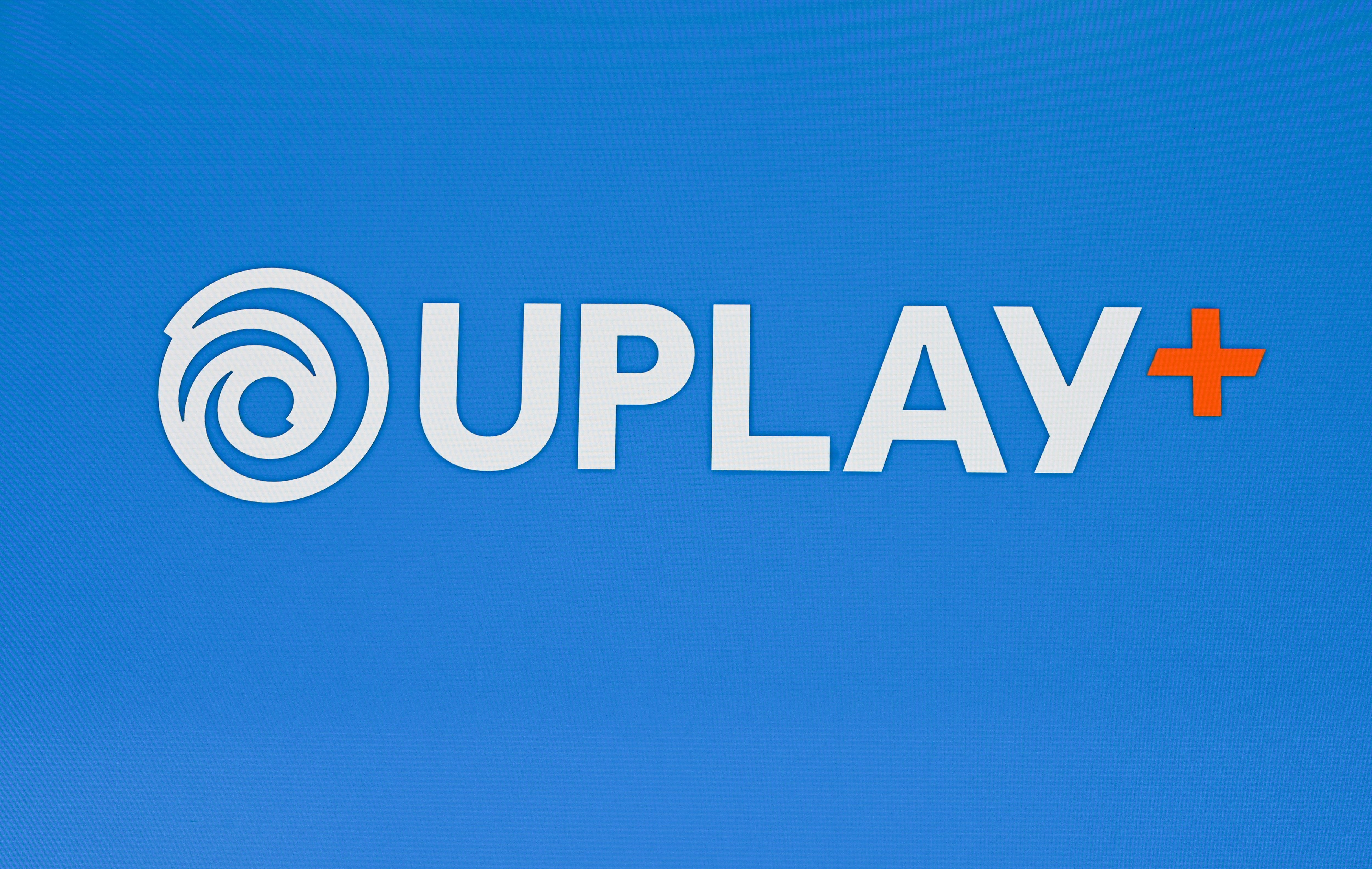 The Uplay+ logo is displayed as Ubisoft's vice president of platform and product management announces the company's new subscription service, Uplay+, June 10, 2019 at the Ubisoft E3 press conference in Los Angeles. - The Uplay+ service, launching September 3 on Window PC, will provide members with access to all the newsest releases including The Division 2, Assassin's Creed: Odyssey, Rainbow Six: Siege and Far Cry 5 as well as in addition to classic Ubisoft titles. (Photo by Robyn Beck / AFP)