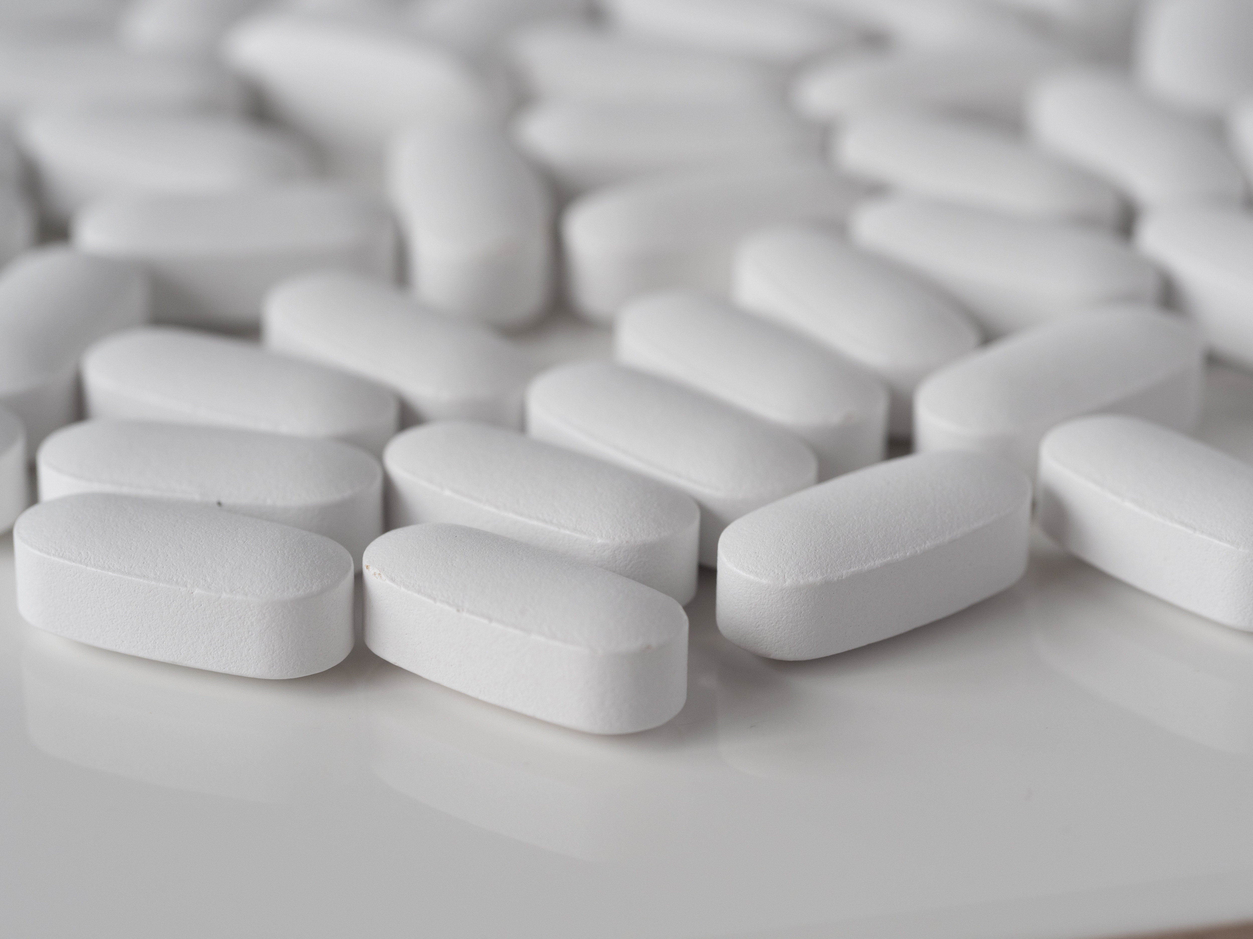 White pills lay on a white surface