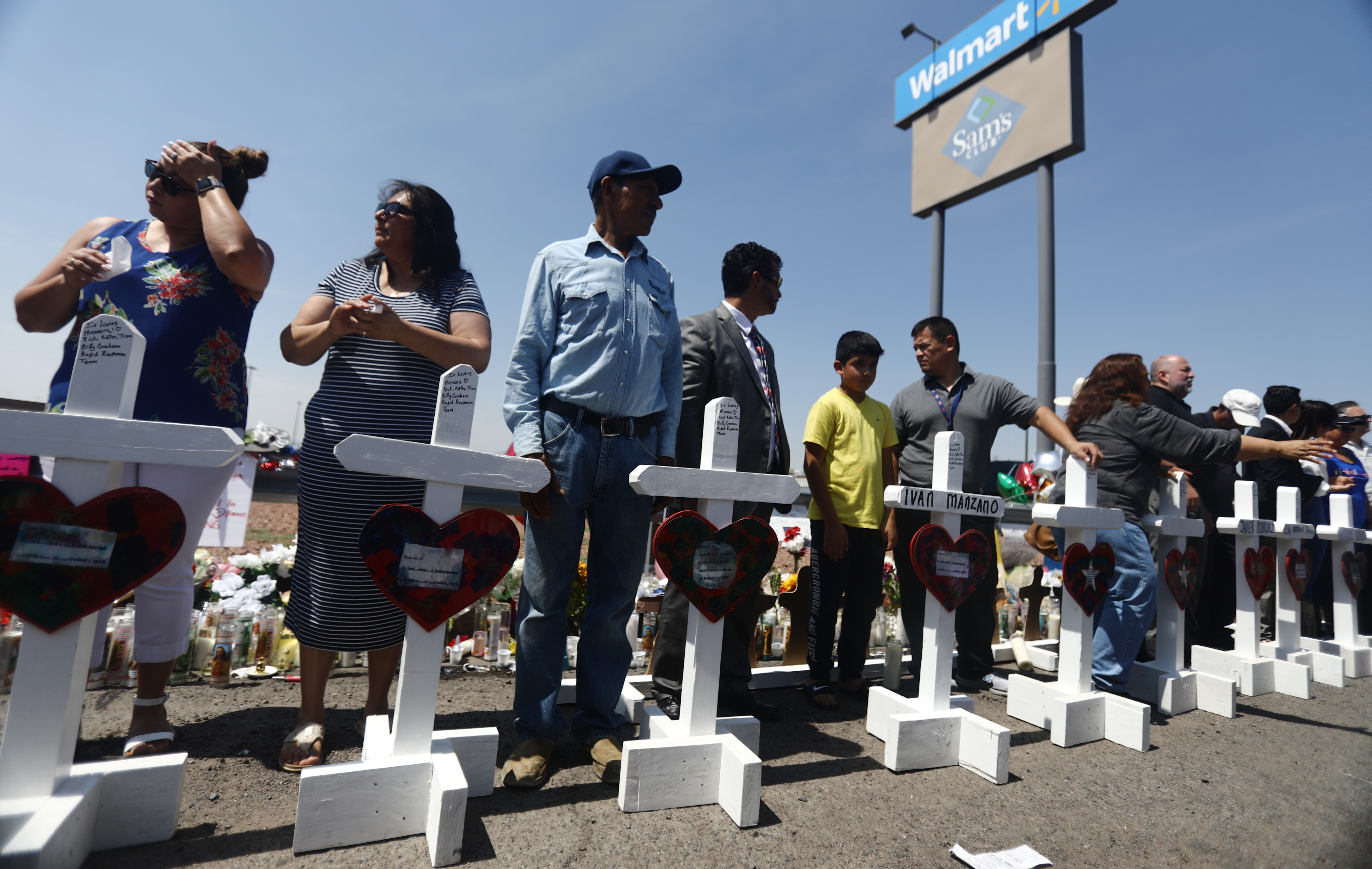 Volunteers stand with handmade crosses memorializing the victims of a mass shooting in El Paso.