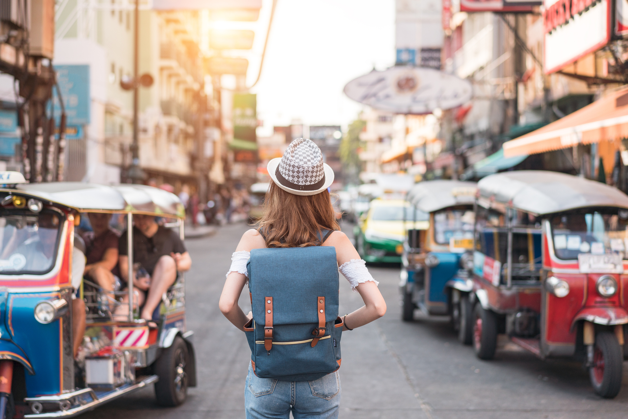The back of a young woman walking and walking along the pedestrian street in the evening in Bangkok, Thailand.