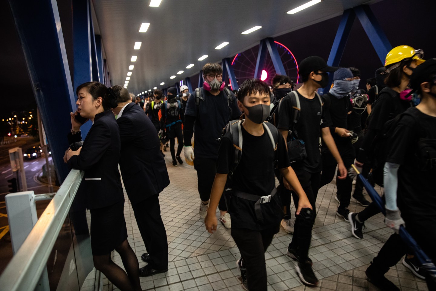 Demonstrators walk on a bridge during a strike rally in the Central district of Hong Kong, China, on Tuesday, Sept. 3, 2019.
