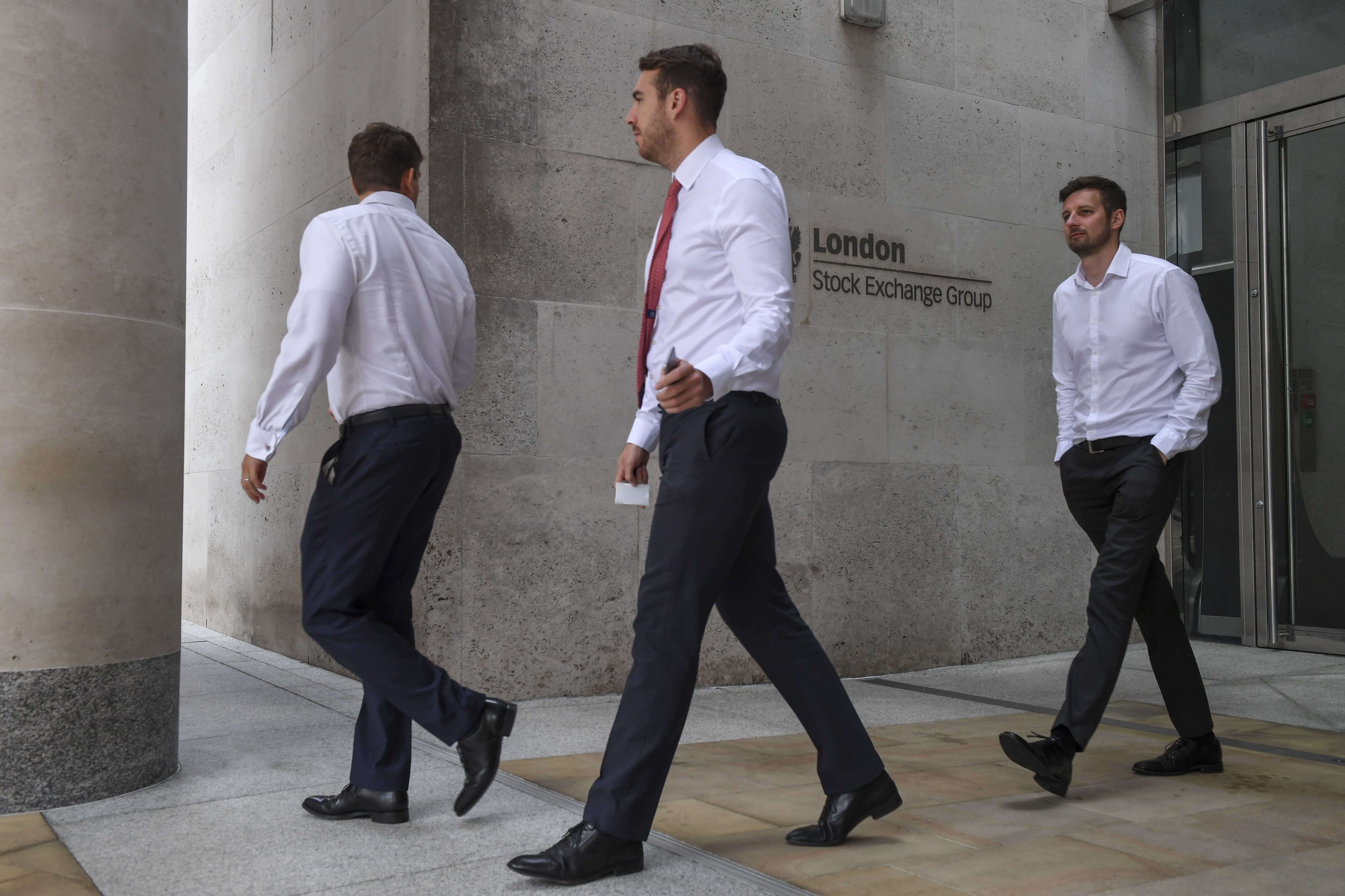 Pedestrians pass a sign at the London Stock Exchange Group Plc headquarter offices in the City of London, U.K., on Wednesday, Sept. 11, 2019. Hong Kong Exchanges and Clearing Ltd. made an unexpected bid for LSE, which could potentially throw the European exchange's own transformative deal into jeopardy. Photographer: Chris J. Ratcliffe/Bloomberg via Getty Images