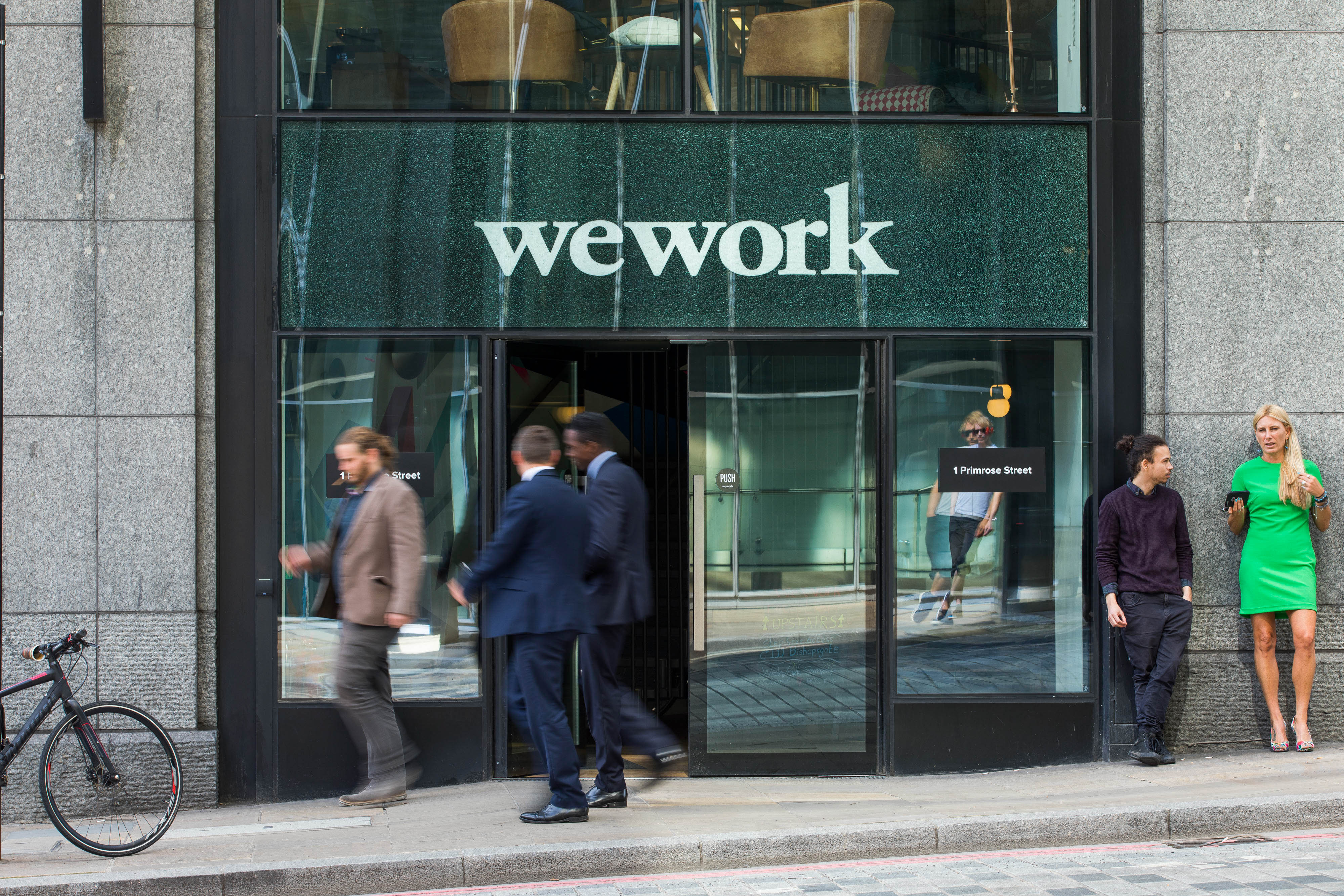Pedestrians pass outside a shared office space, operated by WeWork Cos Inc., in London, U.K., on Monday, Aug. 14, 2017. WeWork Cos Inc. has started legal action against shared-office landlord UrWork in London, accusing its fast-growing Chinese rival of infringing on its trademarks.
