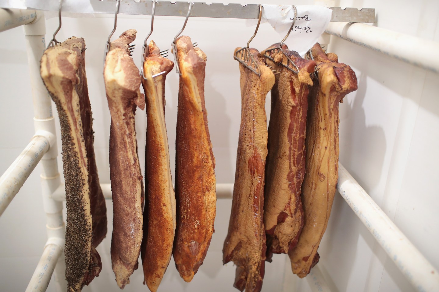 ELMA, IA - JULY 25: Workers smoke bacon while helping to process hogs at Elma Locker &amp; Grocery on July 25, 2018 in Elma, Iowa. The locker custom butchers hogs and cattle and other livestock for area customers. According to the Iowa Pork Producers Association, Iowa is the number one pork producing state in the U.S. and the top state for pork exports. The state sends about 50 million hogs to market each year and its pork exports totaled more than $1.1 billion in 2017. Pork producers in Iowa are bracing for the impact a trade war with China and Mexico may have on their bottom line going forward. (Photo by Scott Olson/Getty Images)