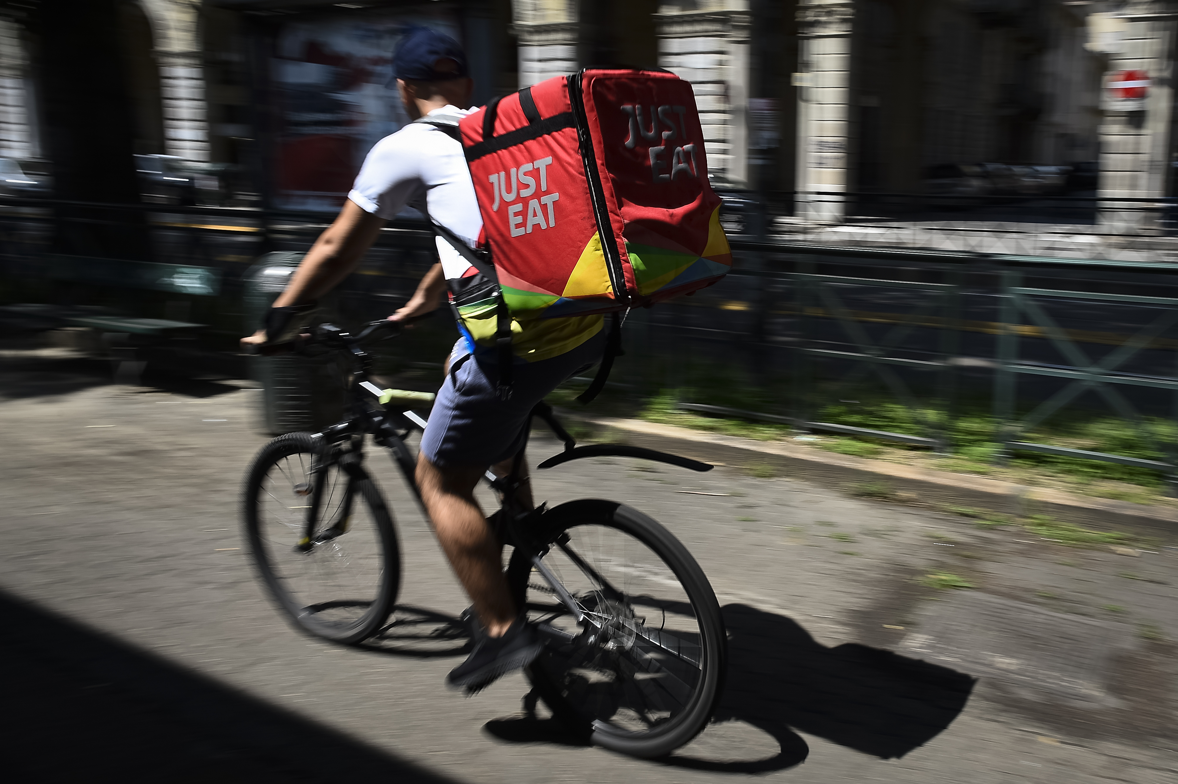 VIA SACCHI, TURIN, ITALY - 2019/08/02: A Just Eat courier rides during his work. Just Eat is a online food delivery app (as Glovo, Uber Eats and Foodora) that hires food riders as independent contractors. (Photo by Nicolò Campo/LightRocket via Getty Images)
