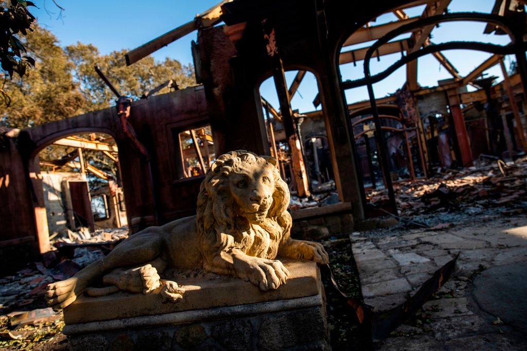 A statue of a lion sits in front of a burned structure devastated by the Kincade fire off Briggs Ranch Road in Kellogg, California on October 31, 2019.