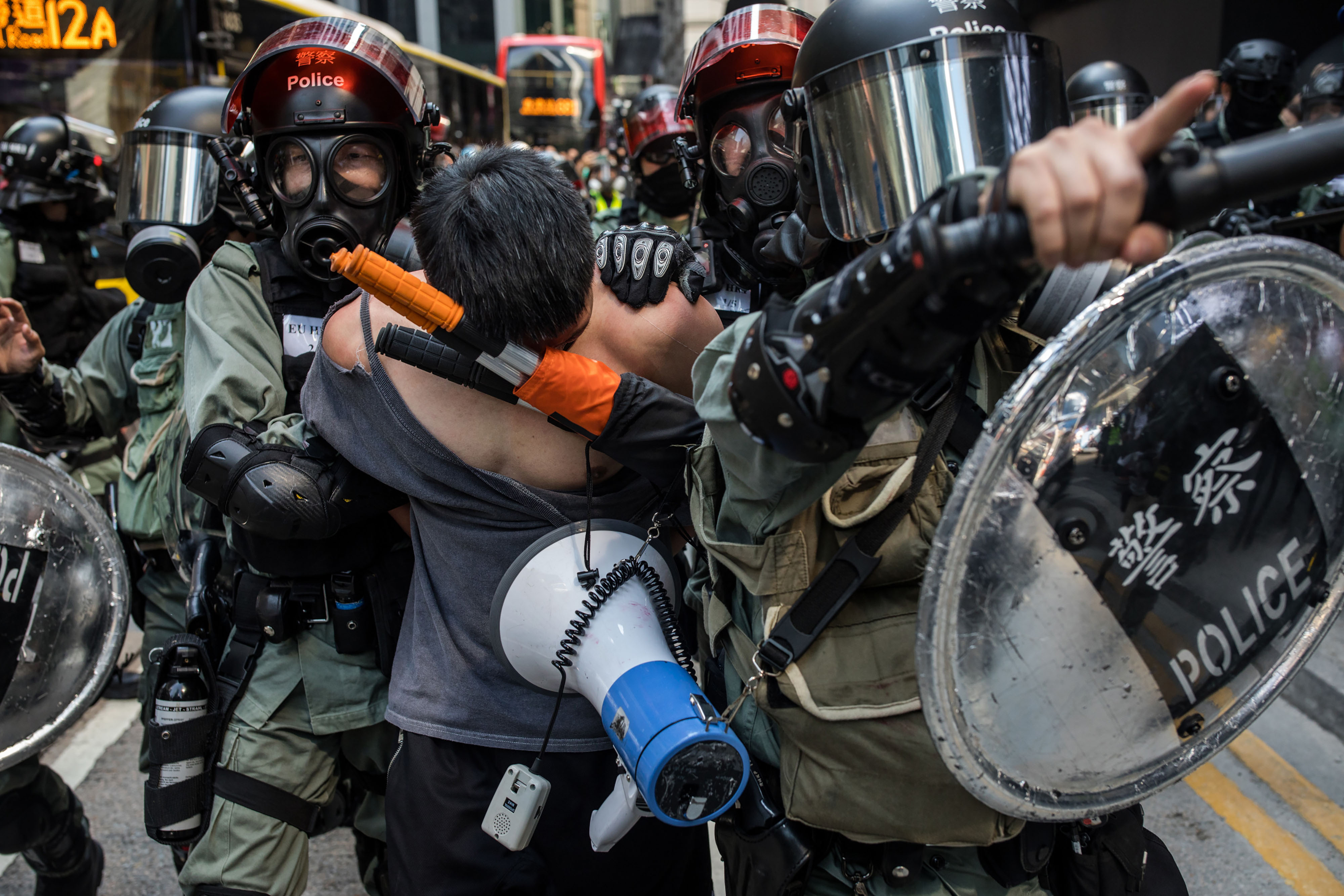 A man is led away by the police during a protest in the Central district of Hong Kong, China, on Monday, Nov. 11, 2019. A Hong Kong protester was in critical condition after being shot by a police officer, as the financial hub reeled from citywide efforts to disrupt the work week amid worsening political unrest. Photographer: Nicole Tung/Bloomberg via Getty Images