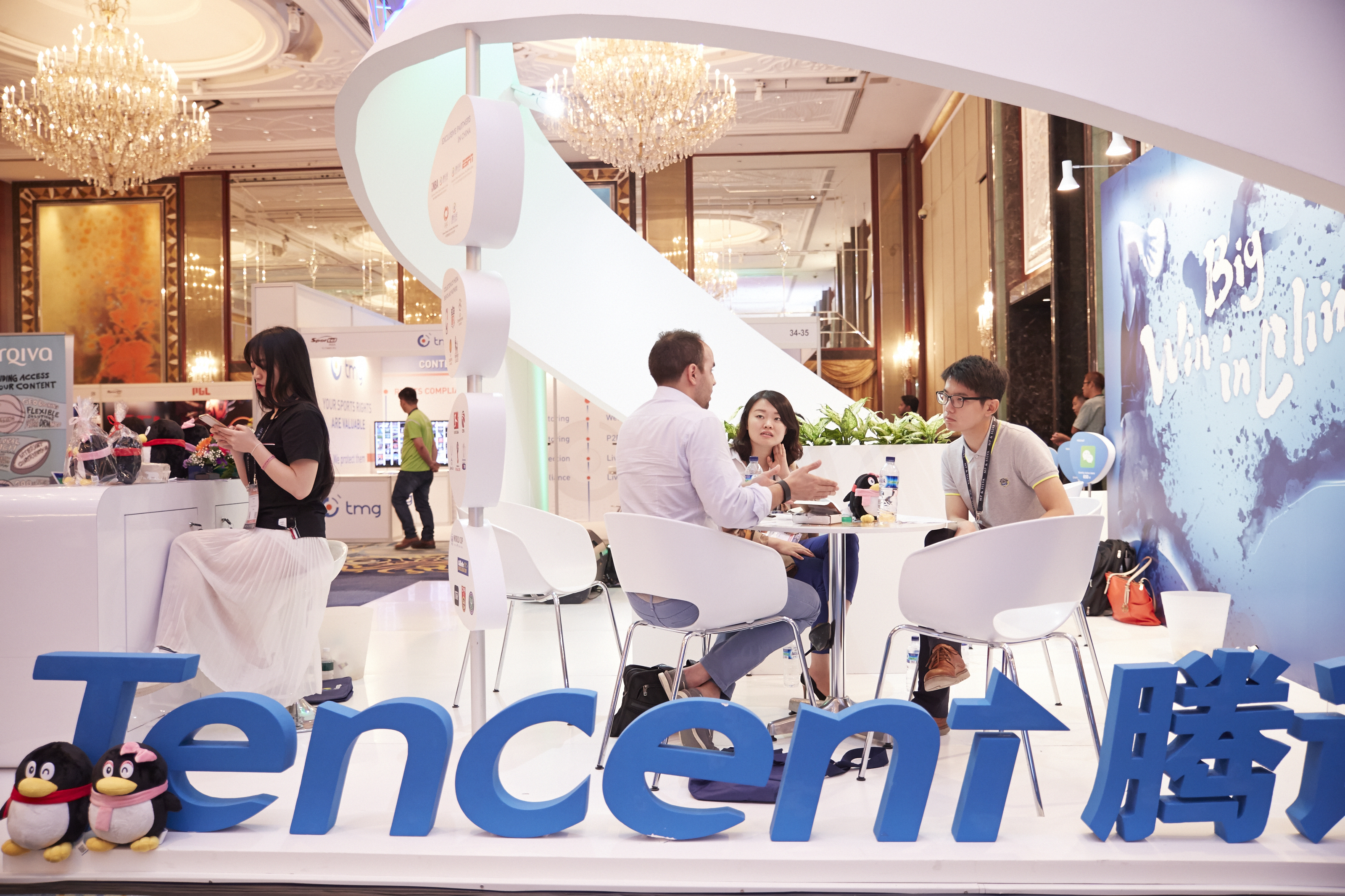 SINGAPORE - MARCH 15: Visitors and exhibitors network at the Tencent booth during the Sportel Asia Conference on March 15, 2016 in Singapore. (Photo by Sean Lee/Getty Images for Sportel)