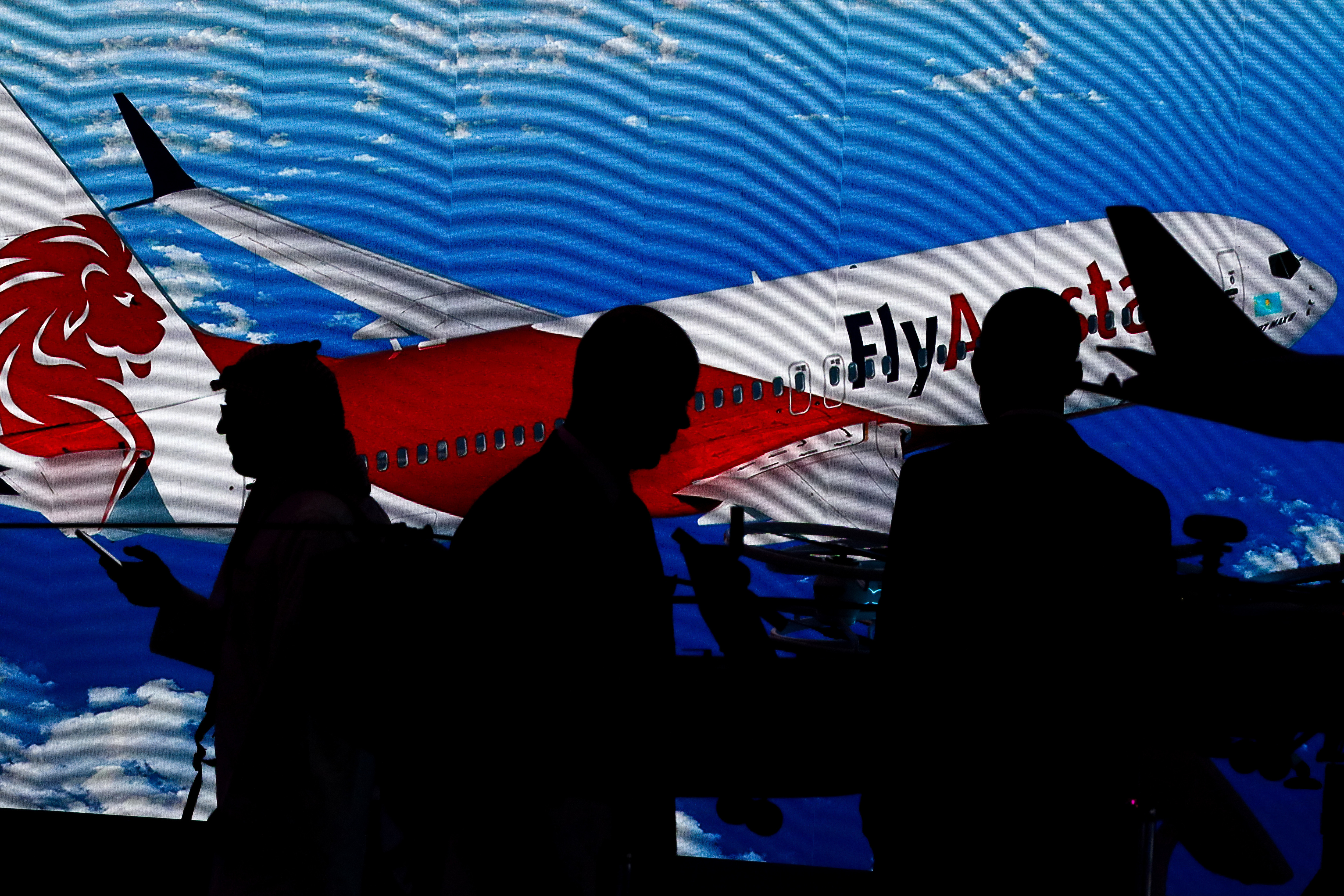 DUBAI, UNITED ARAB EMIRATES - 2019/11/19: Visitors stand next to the image of a Kazakh low cost airline Fly Airstan's Boeing-737 MAX 8, during the third day of the Dubai International Airshow-2019. (Photo by Leonid Faerberg/SOPA Images/LightRocket via Getty Images)