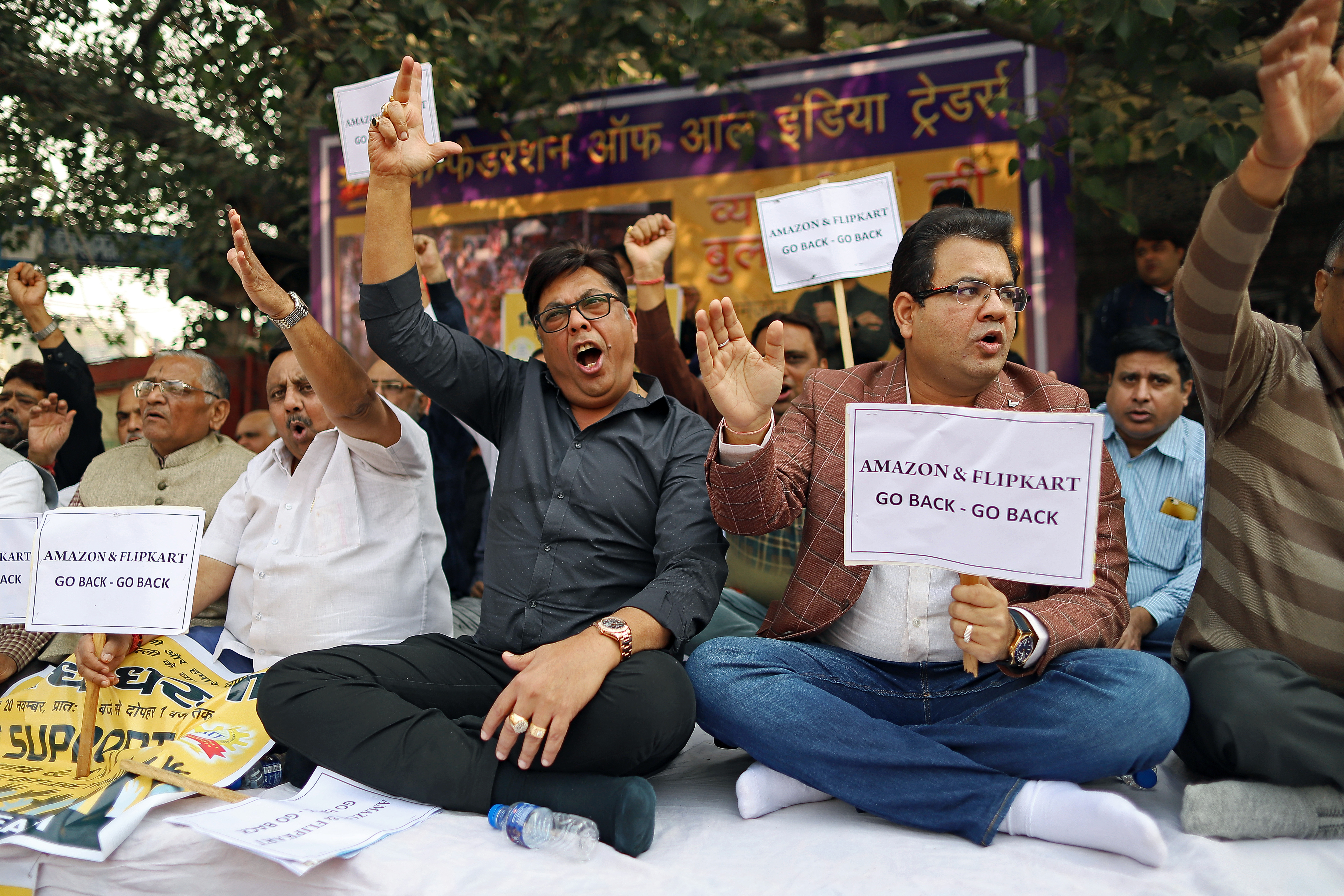Merchants display placards and shout slogans during a sit-in protest at Sadar Bazaar in New Delhi, India, on Wednesday, Nov. 20, 2019. In the heart of New Delhi's largest wholesale bazaar, merchants who normally compete with each other have united against a common enemy. The sit-in, which created more chaos than usual among the rickshaws, motorbikes and ox-carts plying the market road, was one of as many as 700 protests against Amazon.com Inc. and Walmart Inc. -- owner of local e-commerce leader Flipkart -- that organizers say took place at bazaars across India on a recent Wednesday. Photographer: Anindito Mukherjee/Bloomberg via Getty Images
