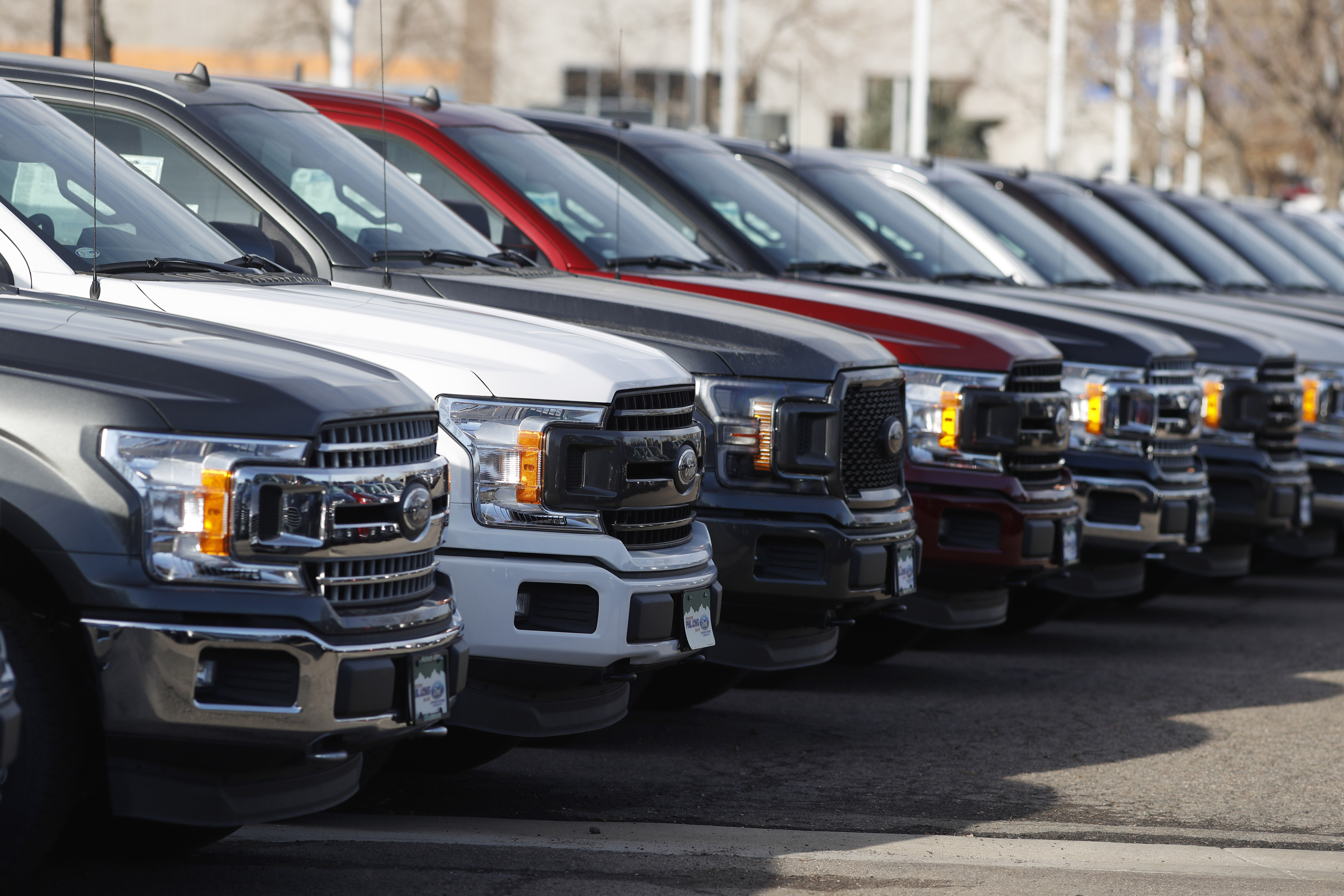 In this Sunday, Nov. 10, 2019, photograph, a long row of unsold 2020 F-150 pickup trucks sits at a Ford dealership in Littleton, Colo. (AP Photo/David Zalubowski)