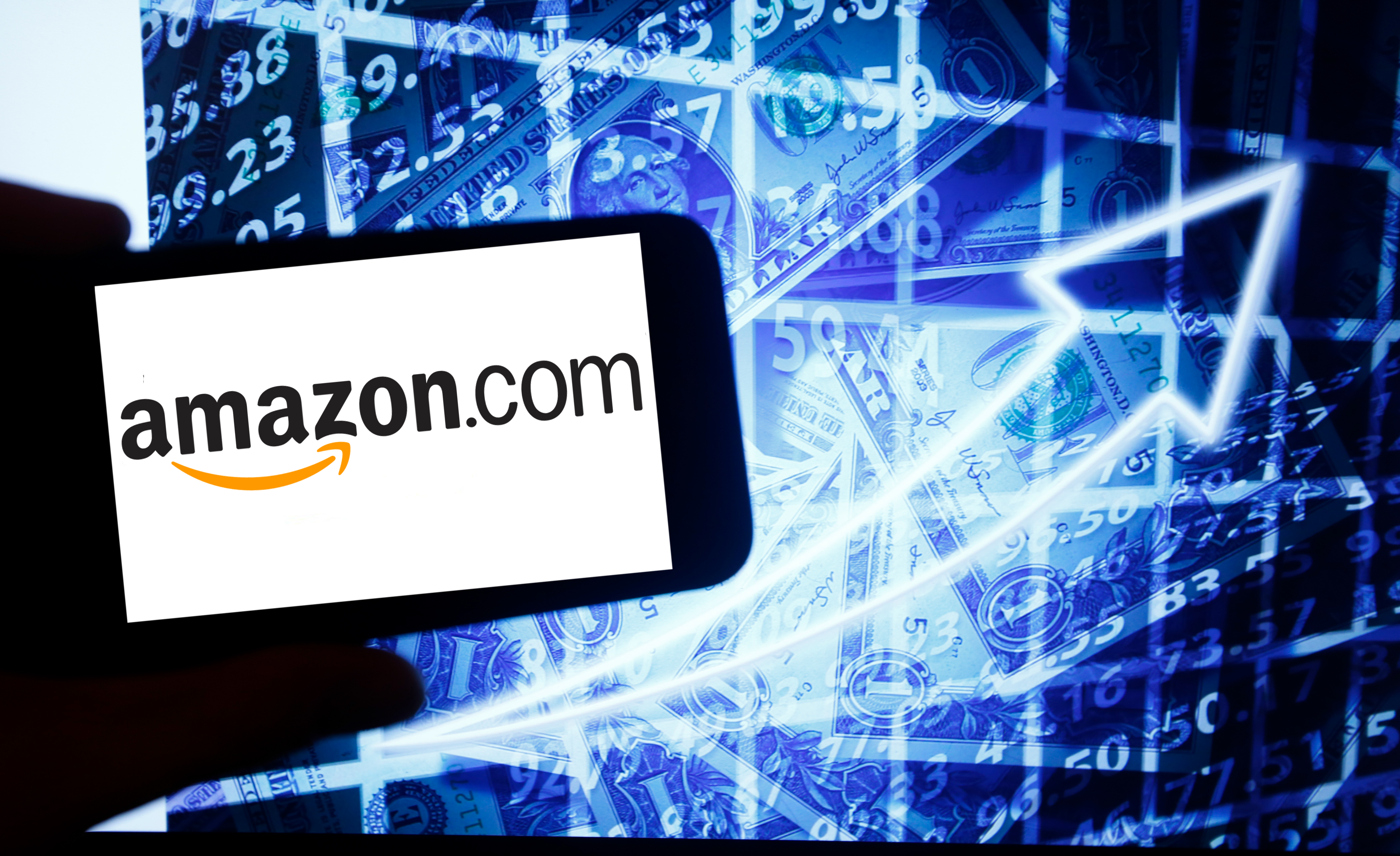 The logo of Amazon is seen on a screen of a smartphone next to a screen with an illustration of the stock market. The tech-heavy Nasdaq is beating all major U.S. indices this year, and is even outpacing gold. Wire photography: Alexander Pohl—NurPhoto via Getty Images
