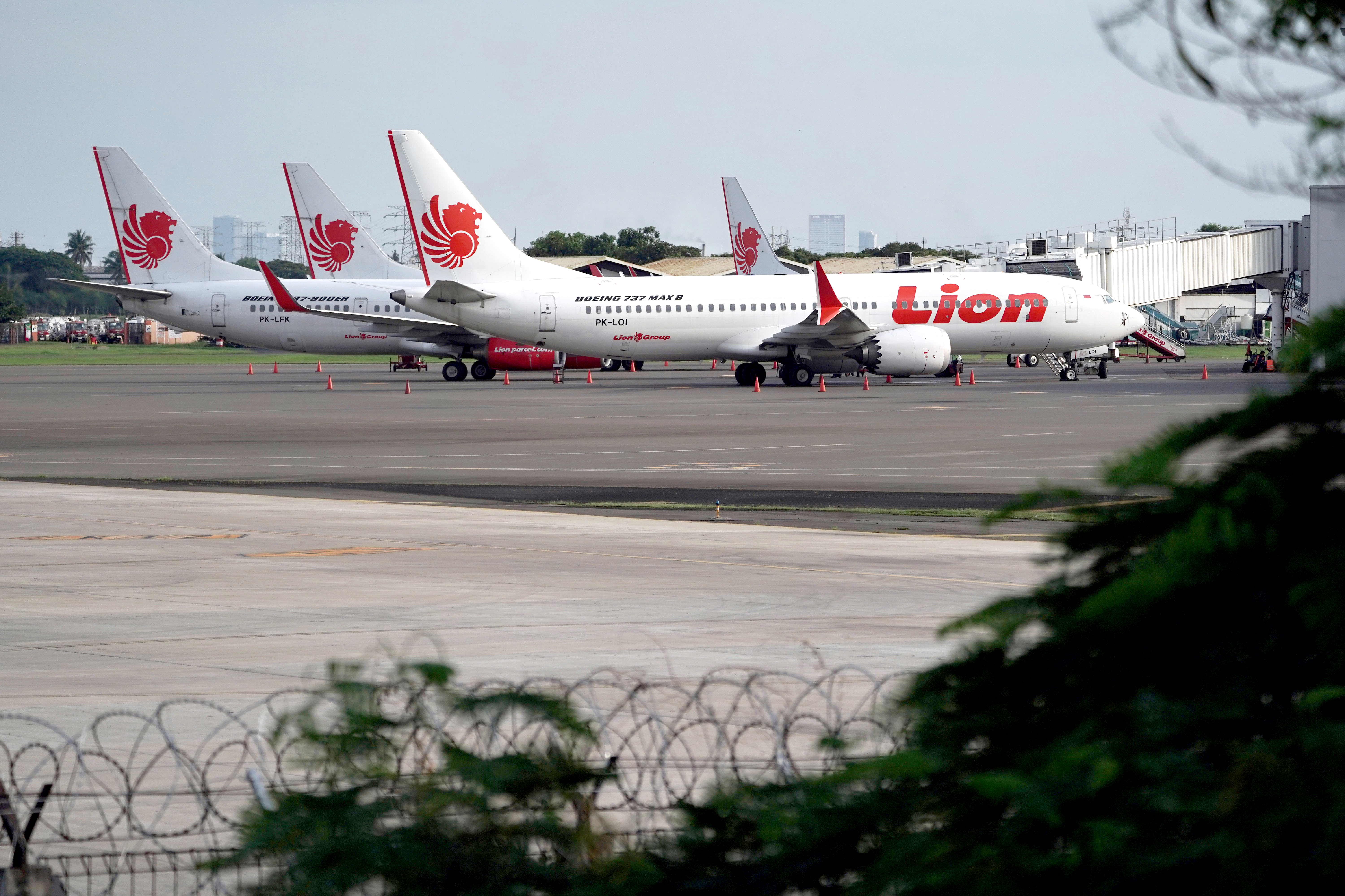 A Lion Air Boeing Co. 737 Max 8 aircraft, right, stands on the tarmac at Soekarno-Hatta International Airport in Cenkareng, Indonesia, on Tuesday, March 12, 2019. Indonesias Lion Air, one of the biggest customers of Boeings 737 Max plane, is suspending delivery of four of the jets it had on order for this year after the second fatal accident involving the model in five months. Photographer: Dimas Ardian/Bloomberg via Getty Images