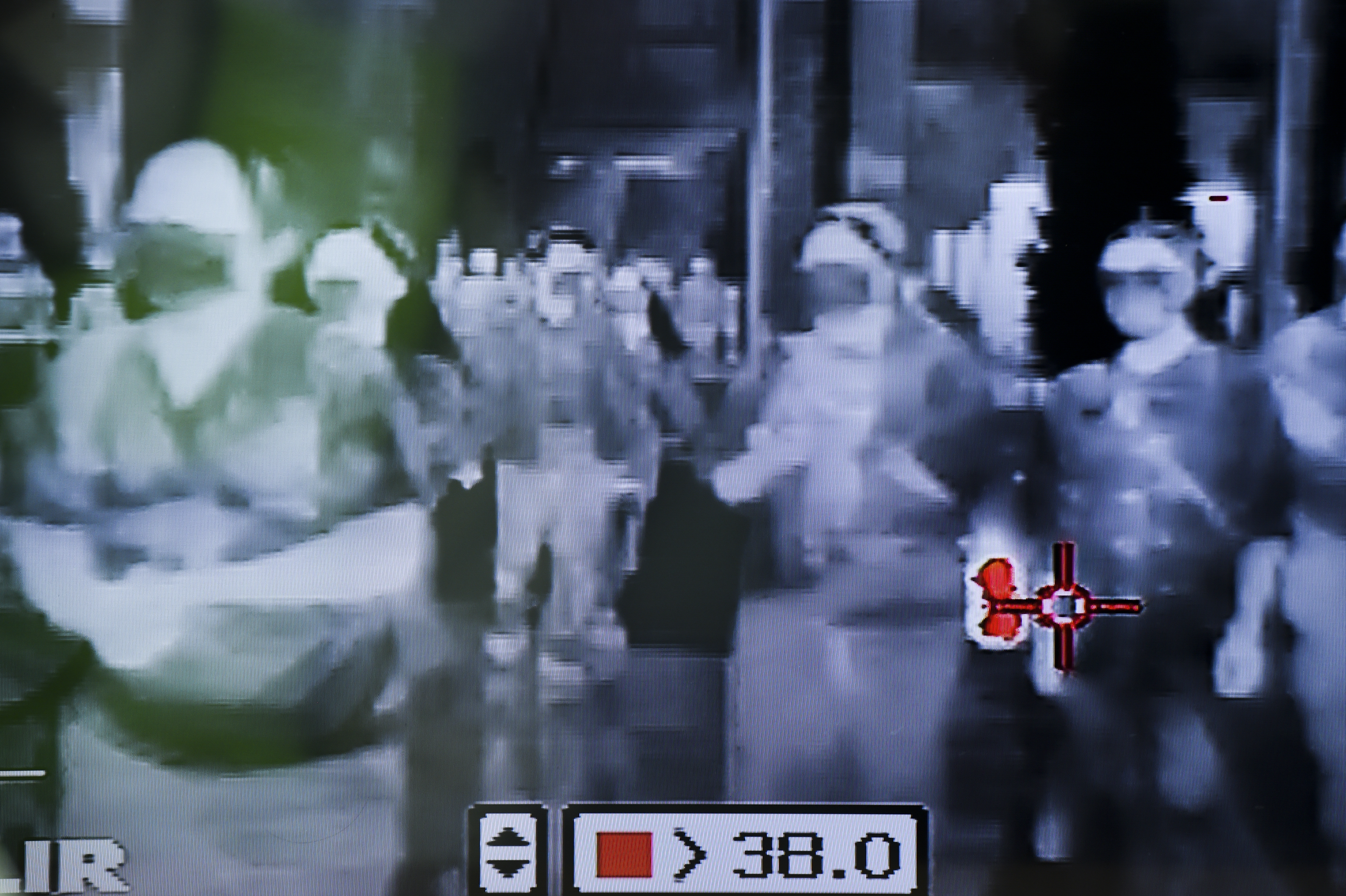 Security personnel use a thermal scanner to check people entering a department store in Bangkok, Thailand, 31 January 2020.