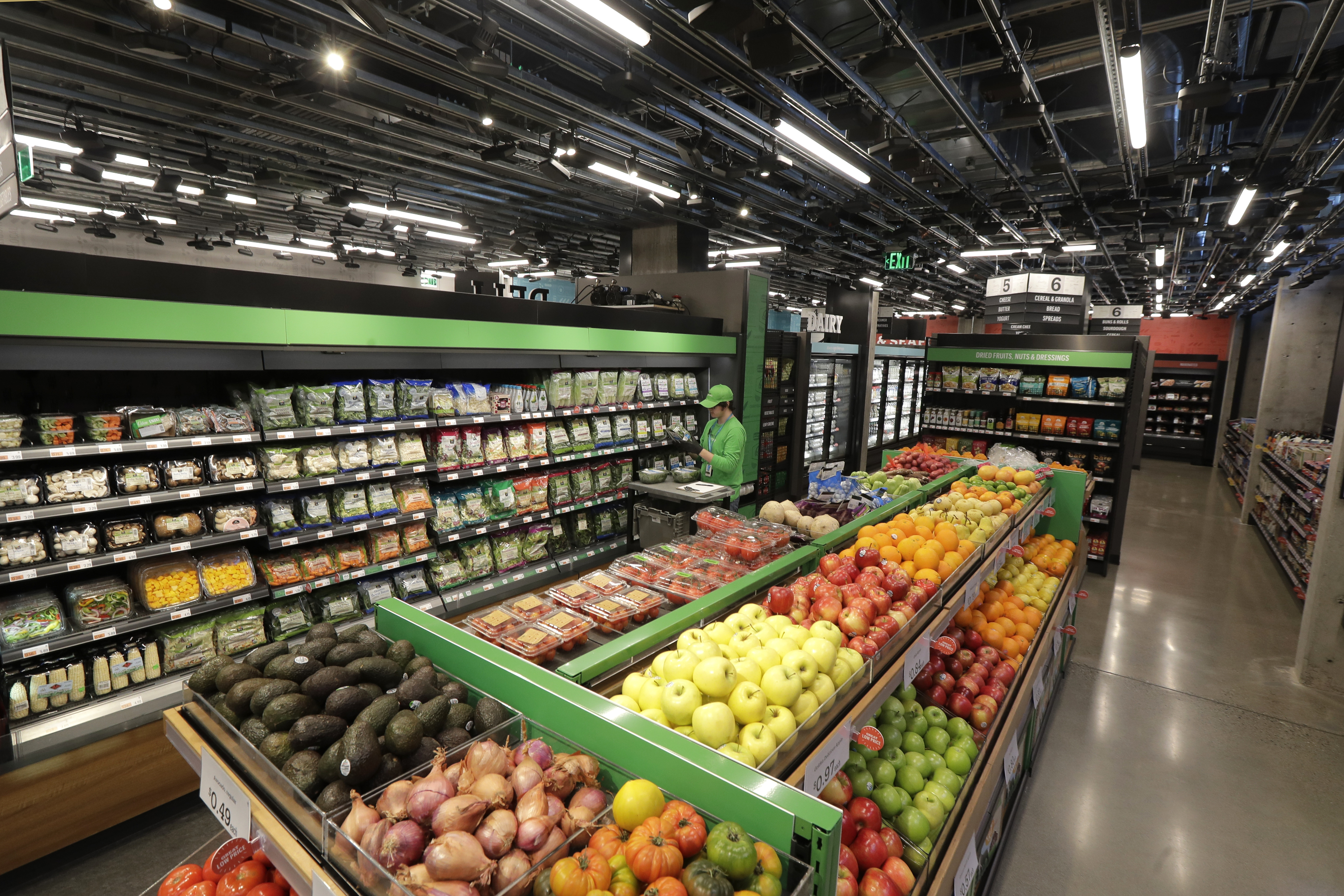A worker checks items on a shelf in the produce section of an Amazon Go Grocery store set to open soon in Seattle's Capitol Hill neighborhood.