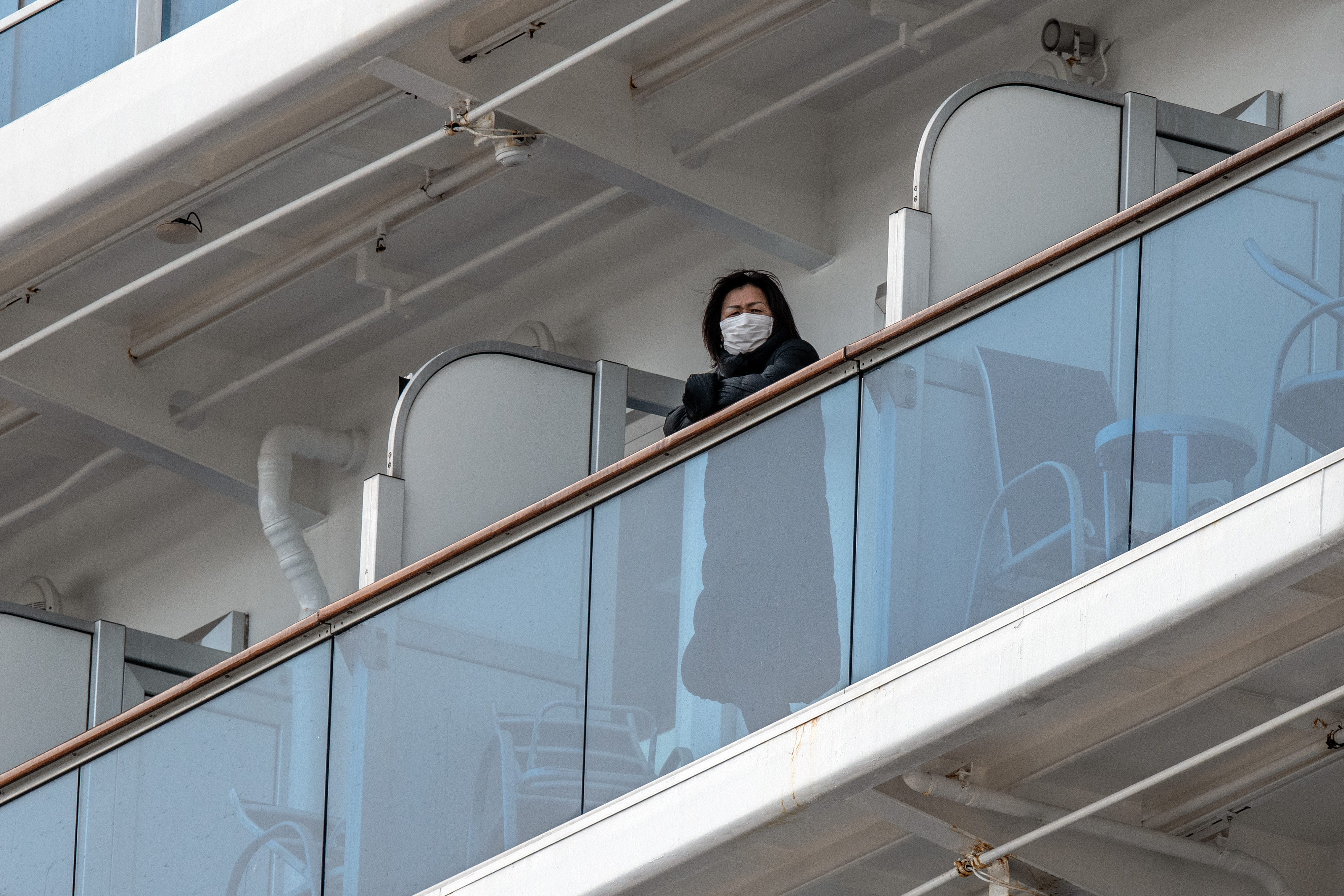 A passenger looks out from a balcony of the coronavirus-stricken Diamond Princess cruise ship while it is docked in the port of Yokohama. Wire photography: Carl Court—Getty Images