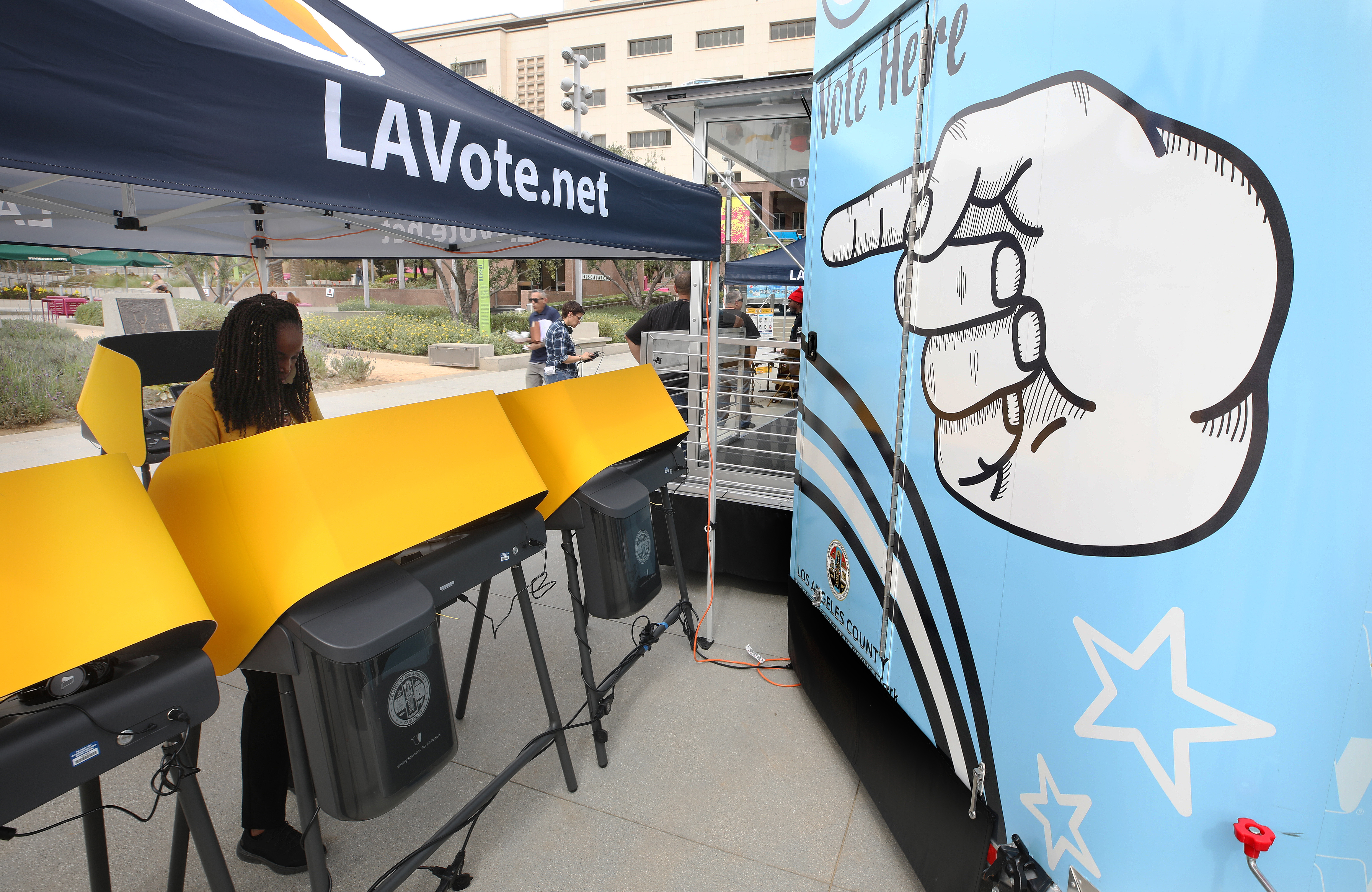 LOS ANGELES, CALIFORNIA - FEBRUARY 27: A voter (L) prepares her ballot in a voting booth during early voting for the California presidential primary election at a new L.A. County ‘Mobile Vote Center’ in Grand Park on February 27, 2020 in Los Angeles, California. Los Angeles County and several other counties in California have transitioned from polling places to ‘vote centers’ which allow residents the freedom to vote in any vote center in the county. California is one of 14 states participating in the Super Tuesday vote on March 3. (Photo by Mario Tama/Getty Images)
